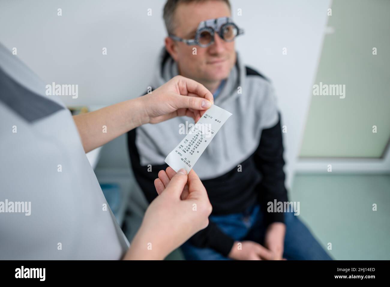 Esame della vista del paziente. Esame visivo. Optometristo che controlla la vista del paziente e la correzione della vista. Paziente sottoposto a controllo visivo con speciale Foto Stock