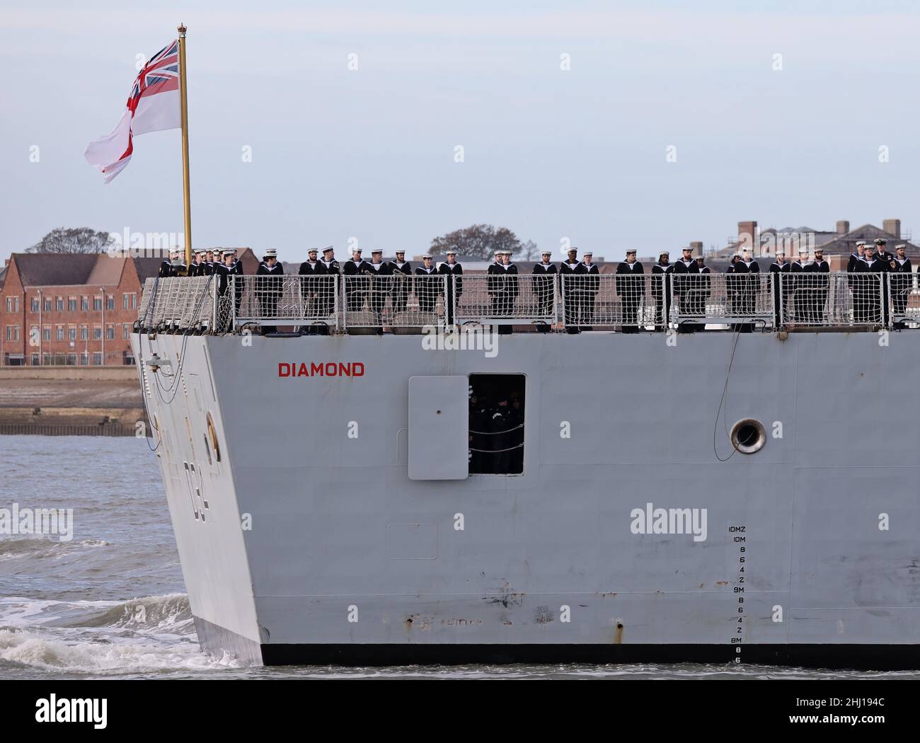 L'equipaggio si trova sul ponte di volo del ROYAL Navy Destroyer HMS DIAMOND, che arriva a casa dopo 7 mesi di dispiegamento in Estremo Oriente Foto Stock