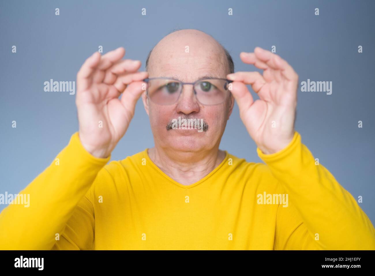 Uomo anziano che controlla i nuovi occhiali. Controllo della vista. scatto studio Foto Stock