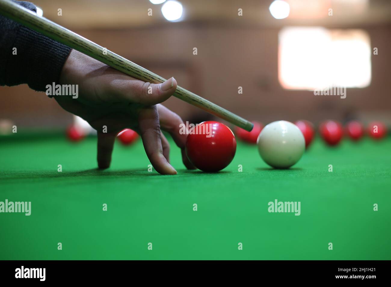 Gaza. 26th Jan 2022. Il giovane palestinese Ahmed Nasr gioca a snooker all'interno di un club sportivo locale nella città meridionale della striscia di Gaza di Rafah, il 26 gennaio 2022. Nasr, 22 anni, imparò a giocare a biliardo e snooker da suo padre, poi imparò le regole del gioco attraverso i video di YouTube. Recentemente ha vinto il primo posto nel campionato di snooker della striscia di Gaza, che lo ha qualificato per il campionato di classificazione a livello della squadra palestinese. Credit: Khaled Omar/Xinhua/Alamy Live News Foto Stock