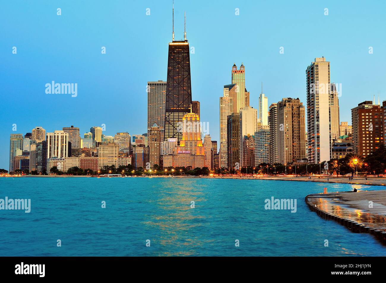 Chicago, Illinois, Stati Uniti. Edifici nello skyline della città come la notte si stabilisce sulla città, mentre alcuni edifici riflettono l'ultima luce del giorno. Foto Stock