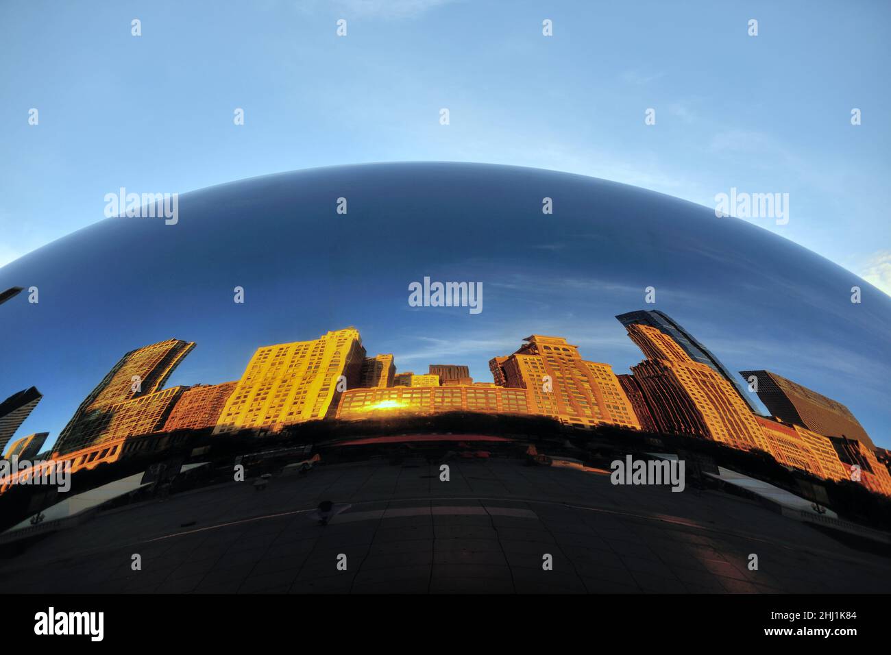 Chicago, Illinois, Stati Uniti. Un'alba estiva riflette gli edifici sulla Michigan Avenue di Chicago che, a loro volta, si riflettono in "Cloud Gate". Foto Stock