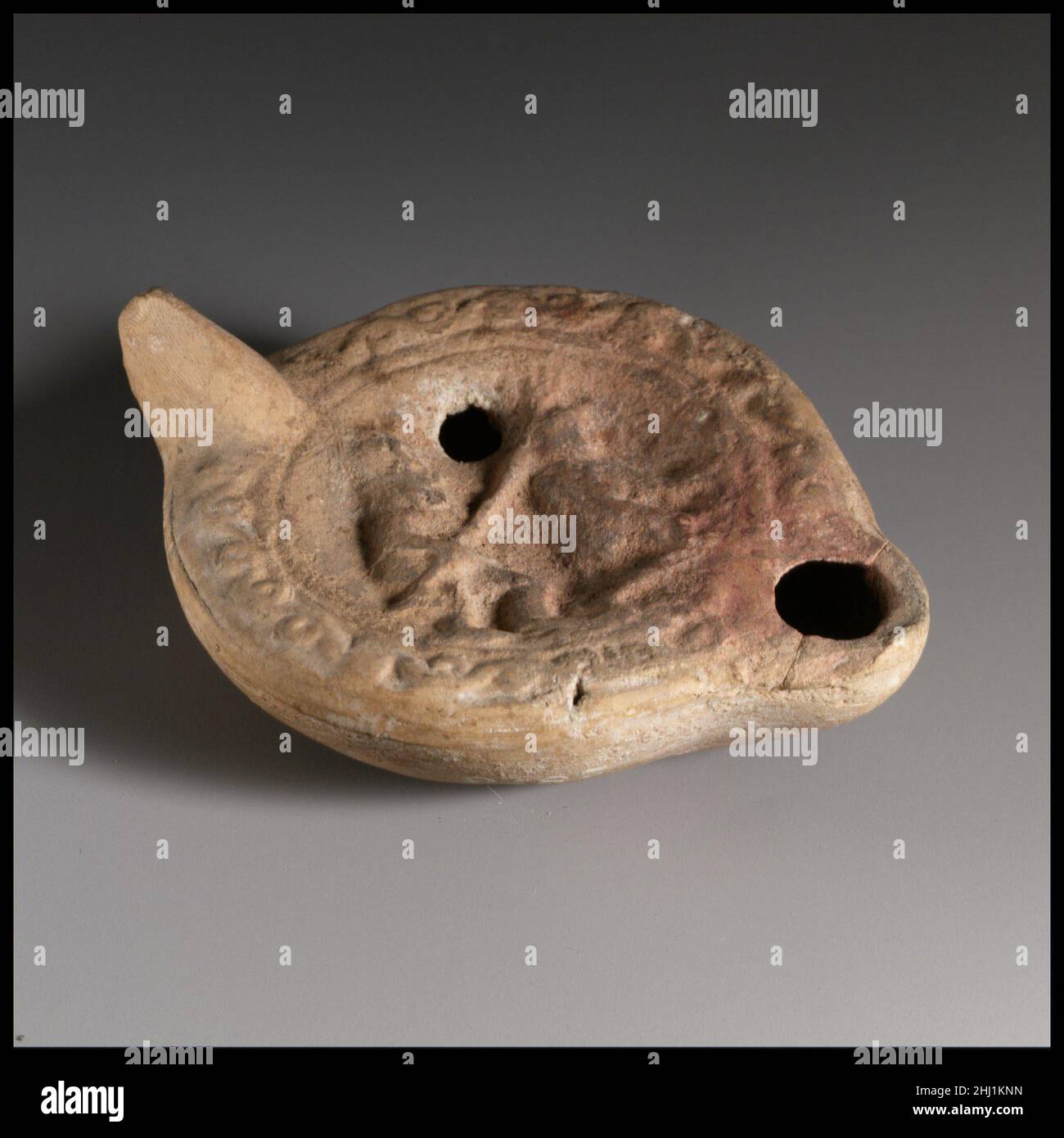 Lampada ad olio in terracotta 2nd secolo d.C. Loeschcke romano tipo 8. Impugnatura non forata. Realizzato in stampo. Discus: Due gladiatori; a sinistra, in piedi in pensione, di fronte a destra e tenendo a lungo assillato il tridente, e, a destra, inginocchiato l'avversario, anch'esso di fronte a destra. Modello di scorrimento rilievo sulla spalla. Sulla base, in greco lettere: XAP (?). Rosso-buccia creta.. Lampada ad olio di terracotta 241812 Foto Stock