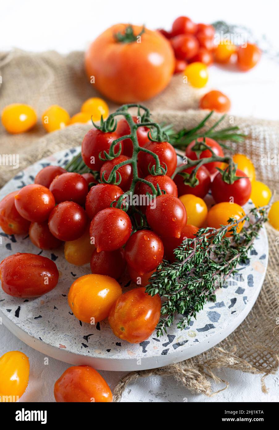 Diversi tipi di pomodori maturi con timo e rosmarino Foto Stock