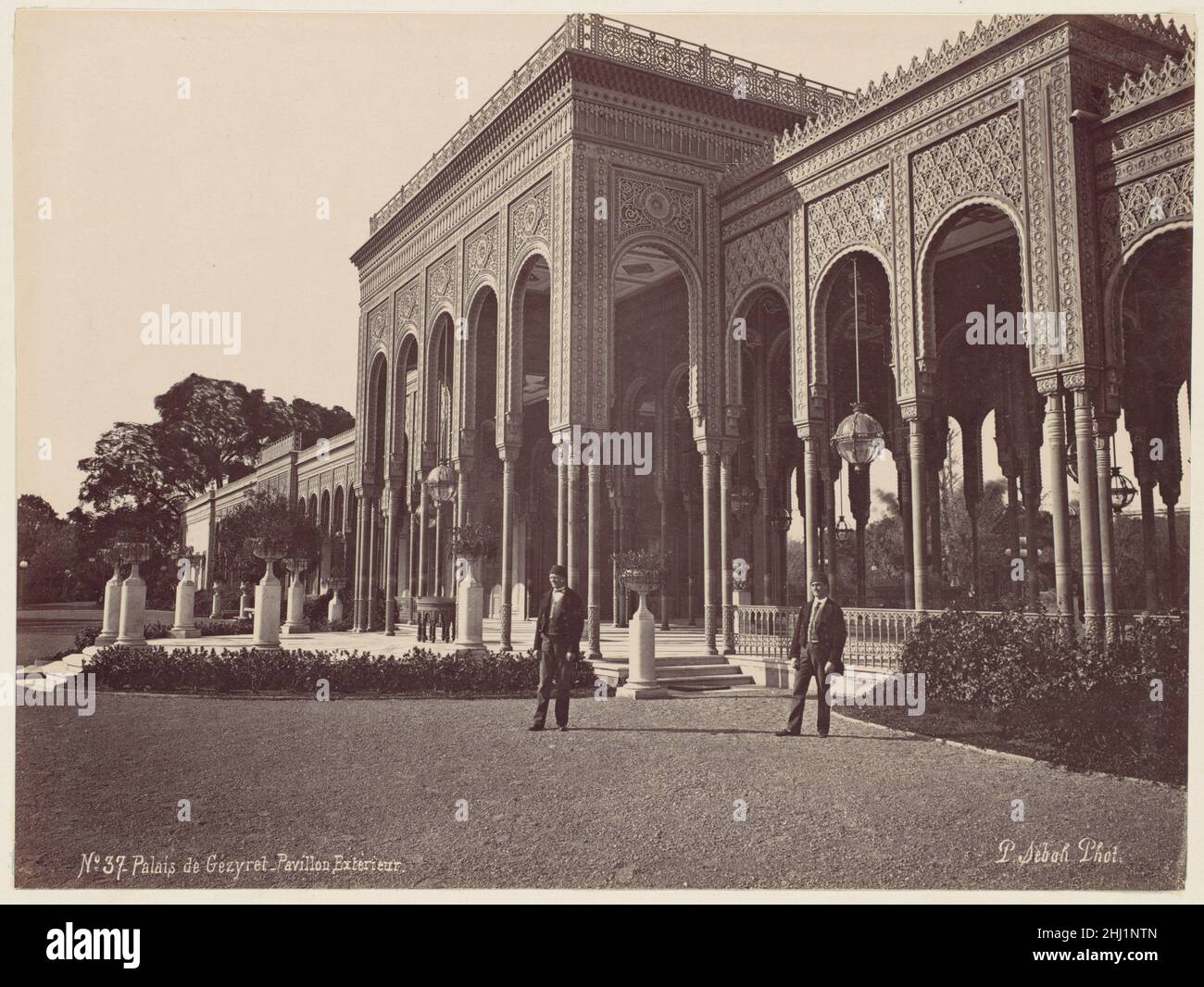 Palais de Gézyret, Pavillon Exterieur 1870s J. Pascal Sébah Turco il Palazzo Gezira sorge sull'omonima isola situata nel fiume Nilo nel centro del Cairo. L'isola fu sviluppata per la prima volta con giardini lussureggianti e un palazzo estivo dal khedive Ismacil (r. 1863-79), e lo scelse anche come sede di questo palazzo costruito per ospitare l'imperatrice Eugénie di Francia per la grande apertura del canale di Suez nel 1869. In seguito, ospiterà anche ospiti statali come il Principe e la Principessa di Galles e l'imperatore Francesco Giuseppe d'Austria-Ungheria. La costruzione del palazzo durò molti anni e invol Foto Stock