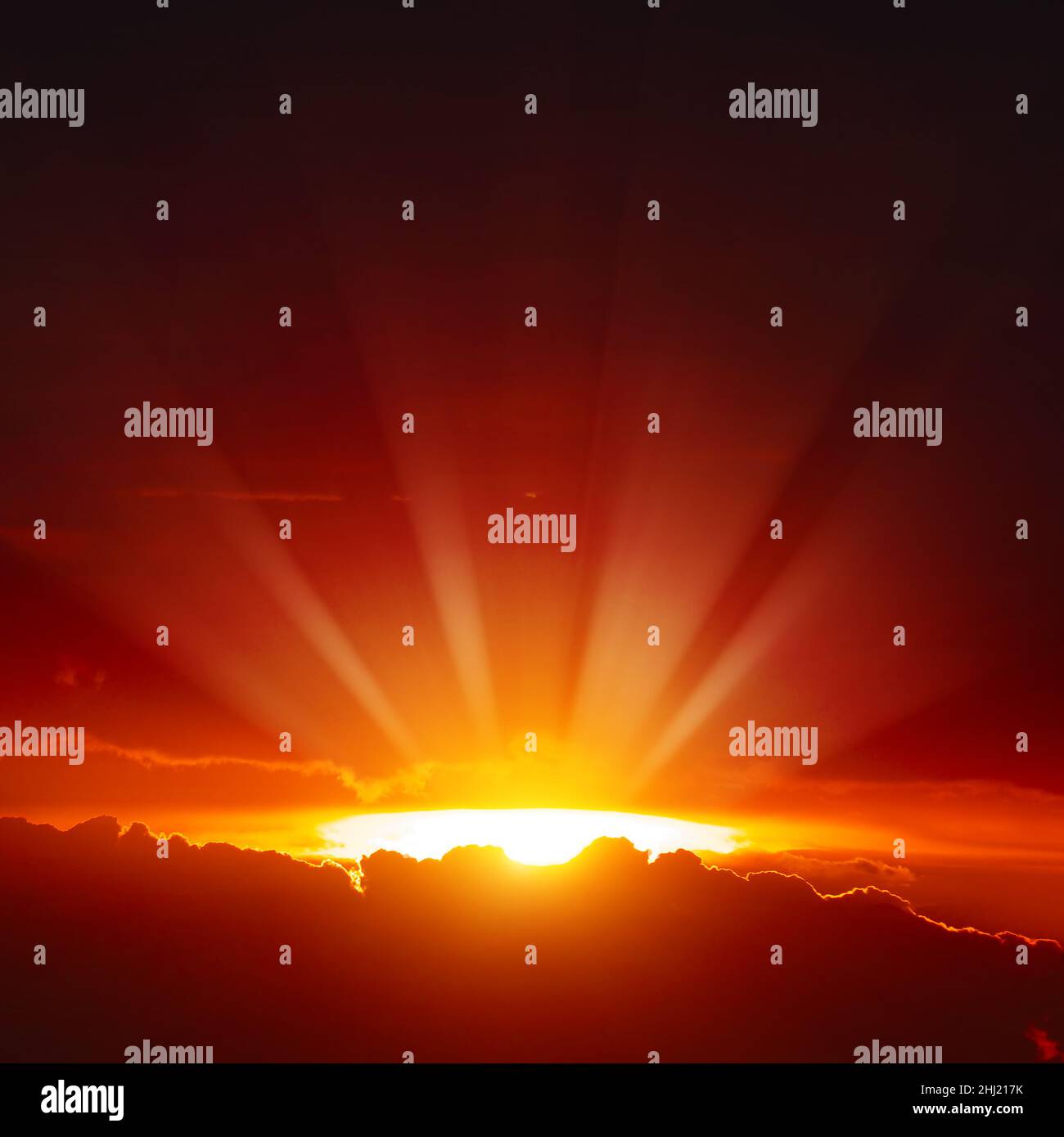 Tramonto maestoso con raggi del sole luminosi sul cielo rosso scuro. Foto Stock