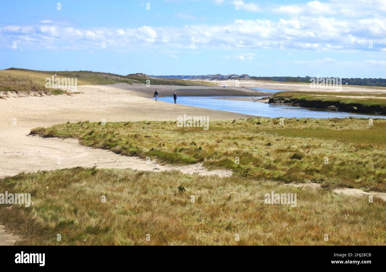 Dune di sabbia, cieli blu, nuvole e insenatura, con due persone a piedi a Sandwich, Cape Cod Massachusetts, Stati Uniti, a Town Beach e Sandwich Harbour. Foto Stock