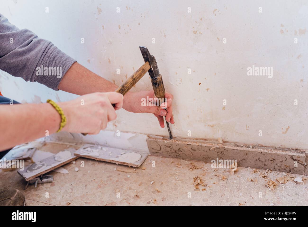 Rimuovere il battiscopa con un martello e uno scalpello Foto stock - Alamy