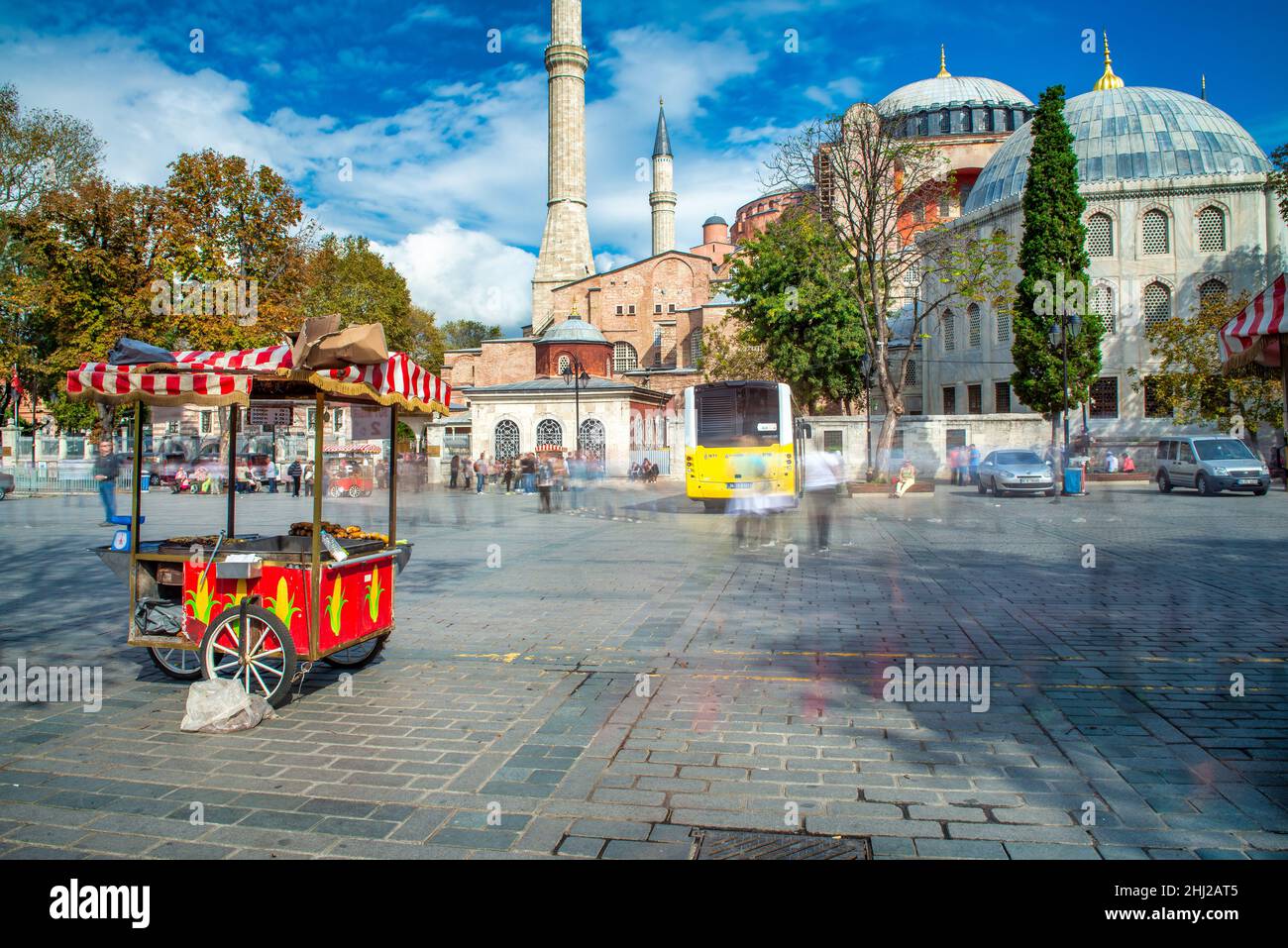 ISTANBUL, TURCHIA - 24 OTTOBRE 2014: Un venditore di strada vende castagne e mais di fronte alla moschea di Hagia Sophia in Piazza Sultanahmet Foto Stock