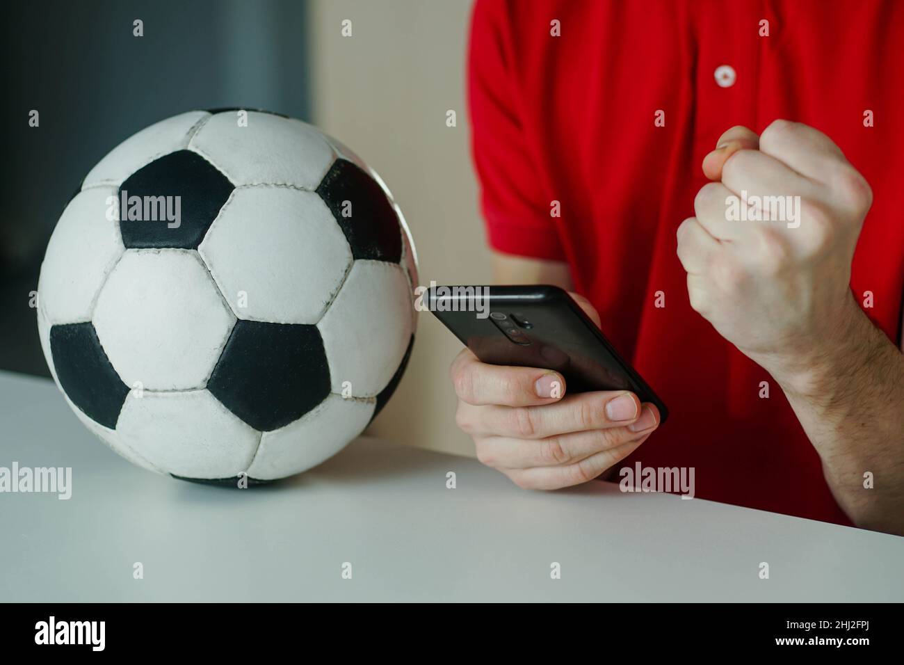 Primo piano del giovane felice festeggia la vittoria della sua scommessa sportiva. Concetto di scommesse, gioco d'azzardo. Foto Stock