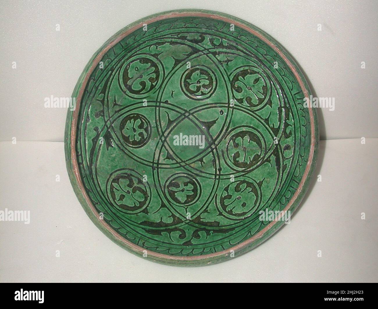 Garrus-Ware Bowl 12th–13th secolo questa ciotola appartiene ad un gruppo noto come Garrus ware, che prende il nome da un distretto a sud-ovest del Mar Caspio, dove si sono trovati esempi. Incarna uno dei più tipici disegni di Garrus ware: Motivi vegetali all'interno di strutture interlacciate. Il disegno è intagliato attraverso il cremoso rivestimento del corpo, esponendo la terracotta rossastra, a cui sono applicati gli agenti oscuranti. Infine l'intero pezzo viene coperto con lo smalto trasparente. Garrus-Ware Bowl 447952 Foto Stock