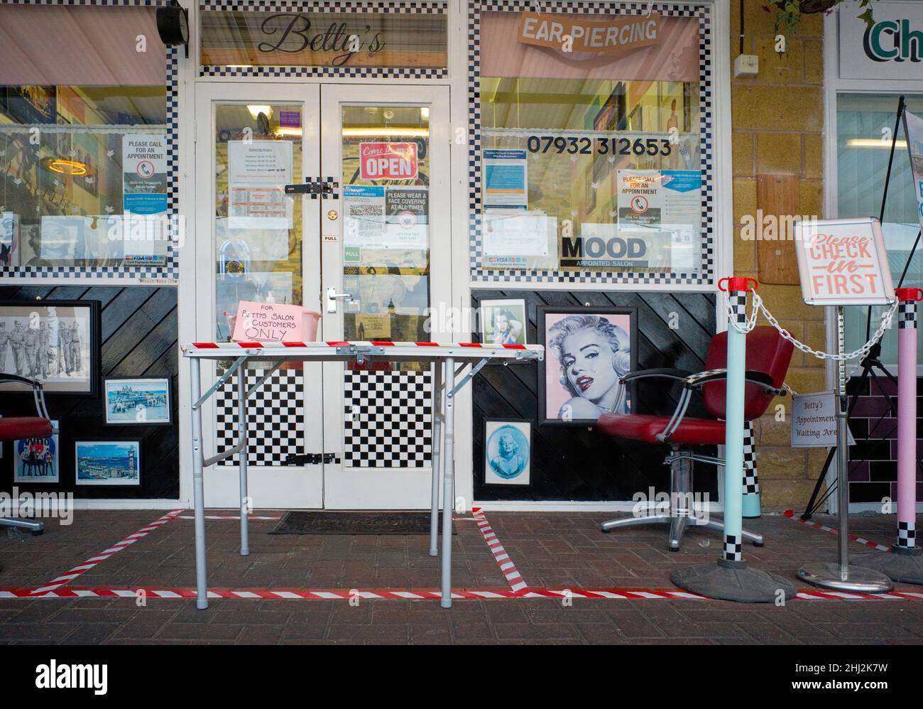 Un sovraccarico di cartelli informativi covid all'esterno di un piccolo salone di parrucchiere a Morecambe, Lancashire Foto Stock