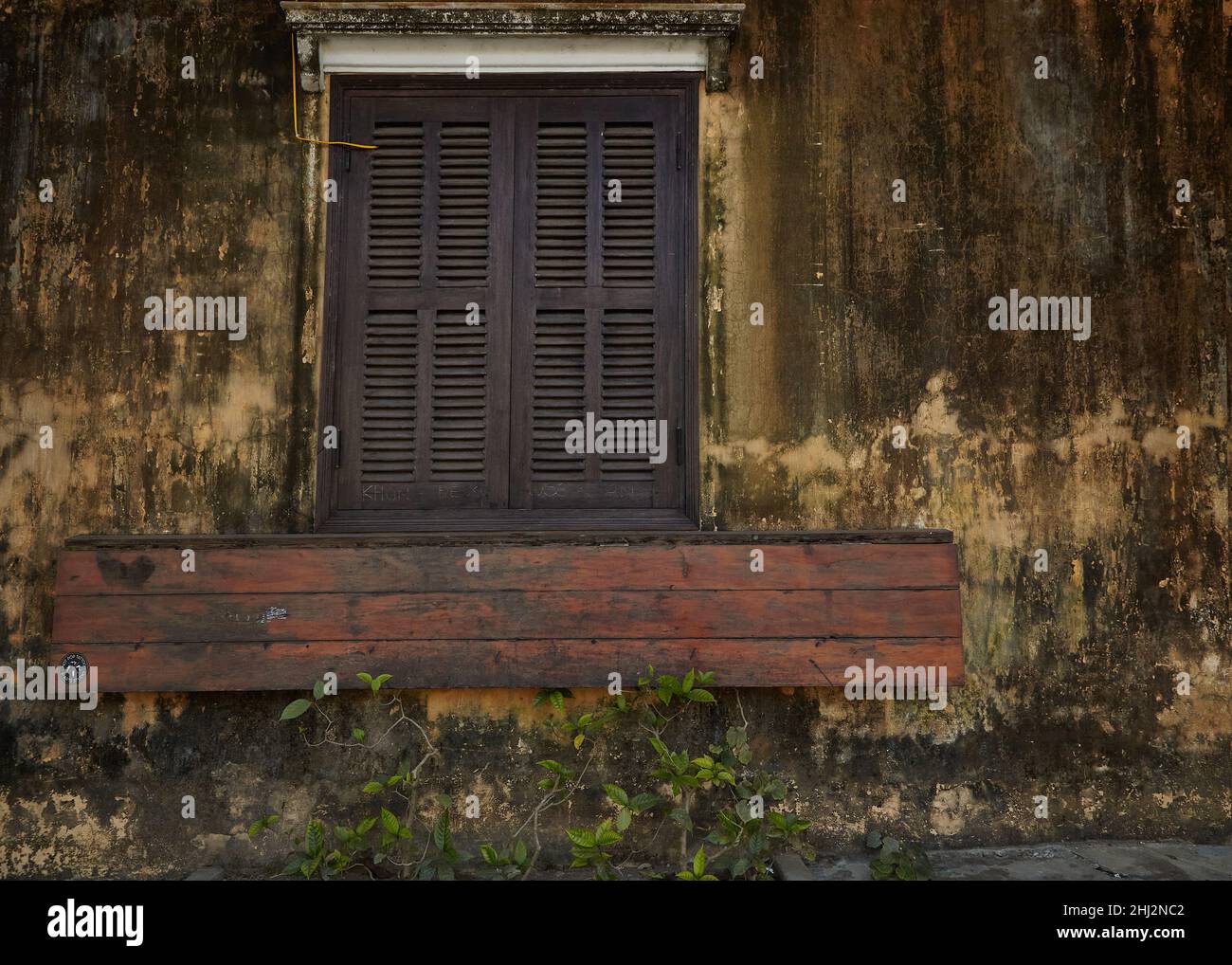 Vecchia parete marrone con persiane finestra nella città antica Hoi An, Vietnam Foto Stock