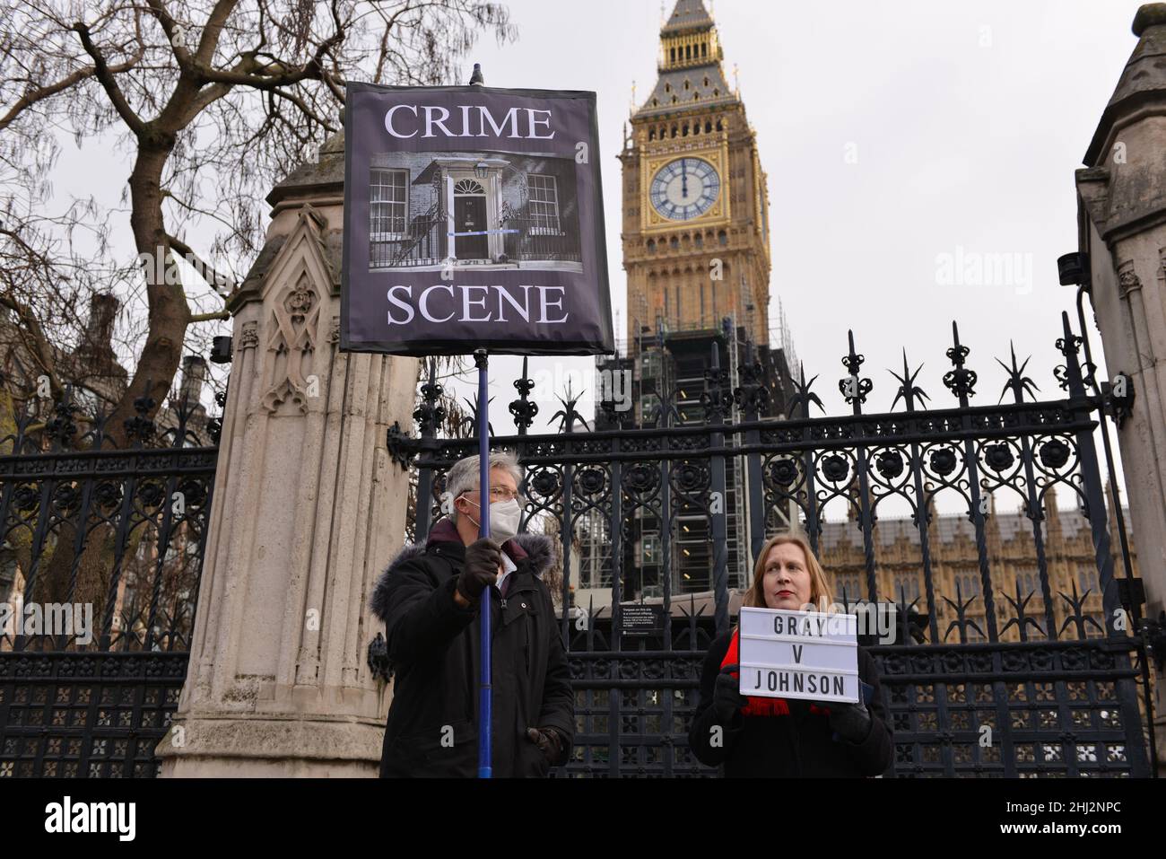 I manifestanti si levano fuori dal parlamento con un cartello raffigurante 10 Downing Street come "scena del crimine" e un cartello anti-Boris Johnson, durante la dimostrazione. I manifestanti si sono riuniti di fronte al Parlamento britannico, mentre Boris Johnson ha affrontato le domande del primo Ministro (PMQ) nel mezzo dello scandalo 'Partygate' Foto Stock