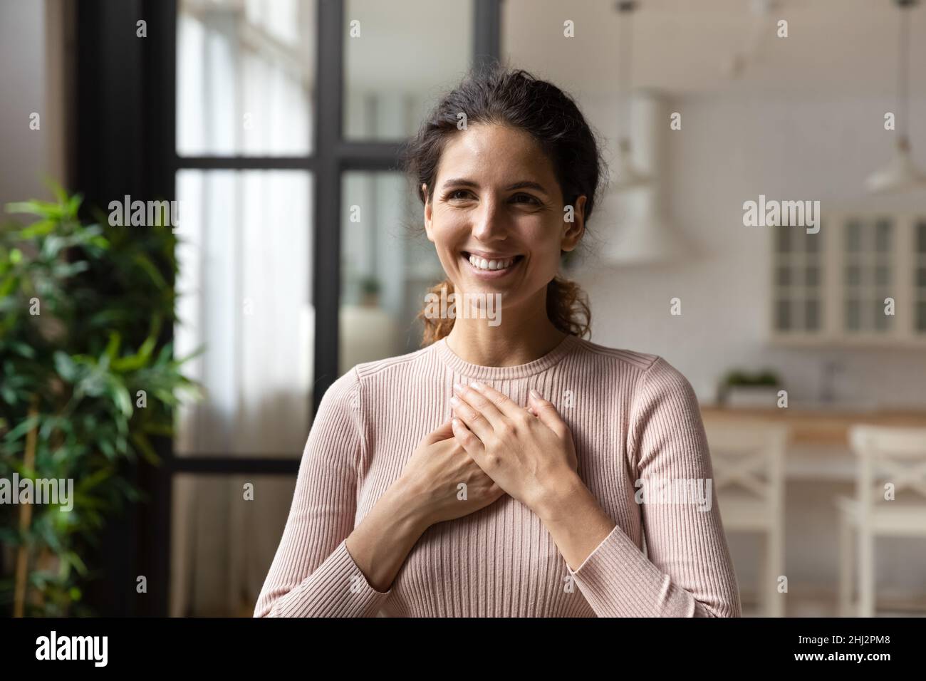 La donna ispanica ha messo le palme piegate sul petto sente gratitudine Foto Stock