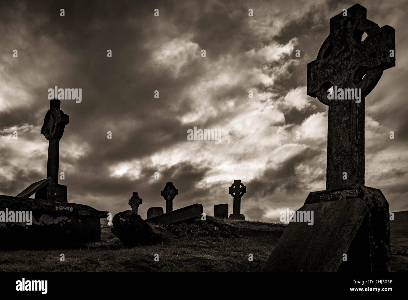 Bianco e nero, la vecchia tomba di Creepy attraversa con cielo nuvoloso, la penisola di Dingle, Kerry, Irlanda Foto Stock