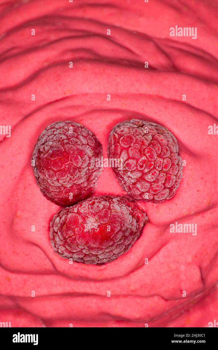 Tre lamponi congelati su un gelato al lampone Foto Stock
