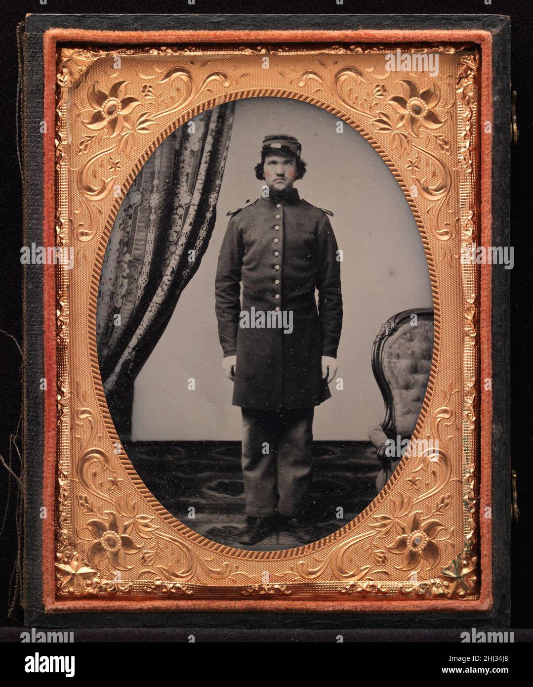[Union Officer Standing at Attention] 1861–65 Sconosciuto questo ritratto formale di un funzionario dell'Unione che sta all'attenzione di uno studio ben nominato è tipico delle migliaia di simili somiglianze di nuove reclute che lasciano la casa, forse per la prima volta nella loro vita. Vestito con un cappotto di camice blu a una volta e pantaloni blu chiaro, il soldato sembra pronto a rispondere a qualsiasi sfida gli venga chiesto. [Union Officer in piedi all'attenzione] 301903 Foto Stock