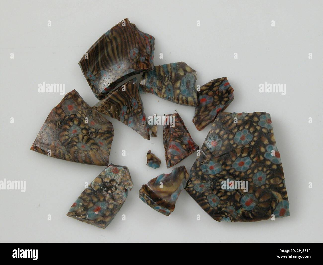 Frammenti di vetro mosaico da un vaso 4th–inizio 5th secolo il vetro mosaico copto era uno dei tipi di vetro di lusso più pregiati del mondo antico. Prende il nome dal modo in cui i vasi sono formati da un mosaico di aste (segmenti monocromatici di vetro) e coni (aste sottili impacchettati e fusi per formare disegni policromi). Tra il 1907 e il 1909, il Metropolitan Museum scavato ad Ain et-Turba nell'Oasi di Kharga. Gli escavatori hanno trovato un gran numero di frammenti di vetro, molti di alta qualità e costoso fabbricazione. Frammenti di vetro mosaico da un vaso 477124 Foto Stock