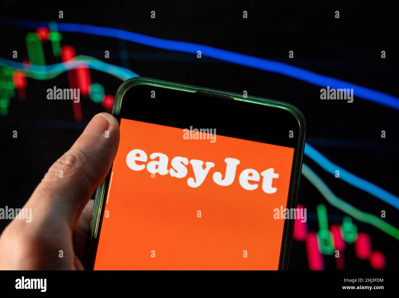 Cina. 4th Dic 2021. In questa illustrazione della foto il logo EasyJet della multinazionale britannica low-cost della compagnia aerea visto su uno smartphone con un grafico di indice di borsa economica sullo sfondo. (Credit Image: © Budrul Chukrut/SOPA Images via ZUMA Press Wire) Foto Stock