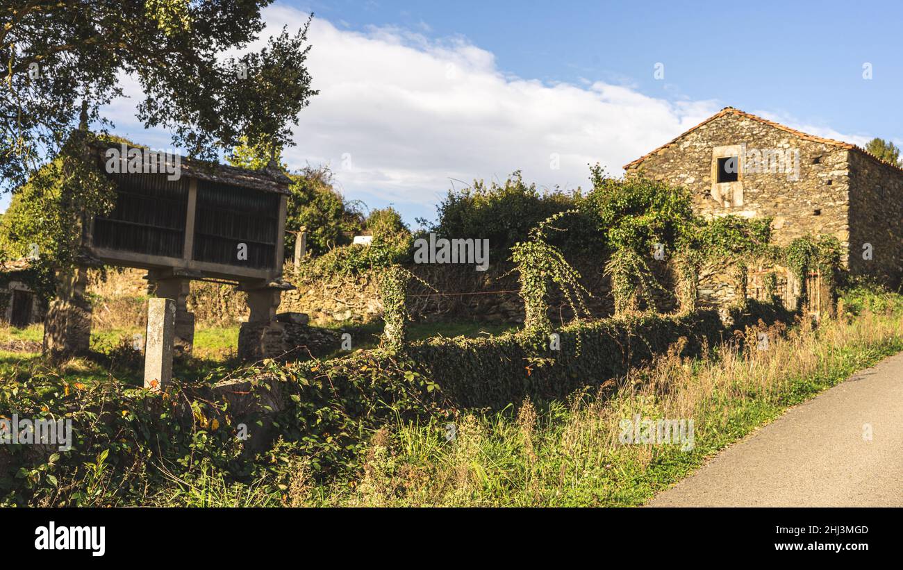 Il sole tramonta da qualche parte in Galizia dove si può vedere un vecchio edificio accanto ad un albero e prati verdi Foto Stock