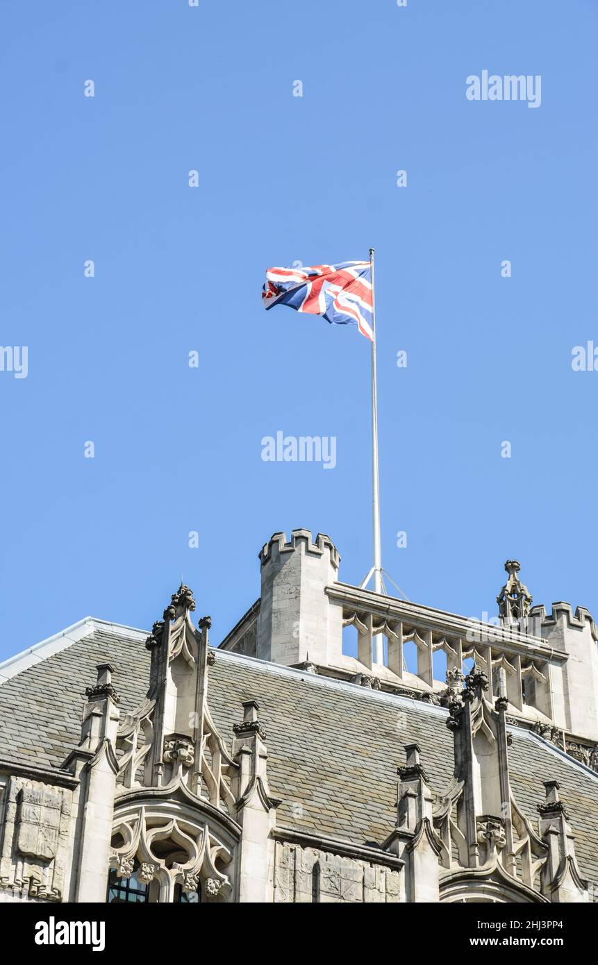 Colpo verticale della bandiera Union Jack che sventola in cima a un edificio storico a Londra, Regno Unito Foto Stock