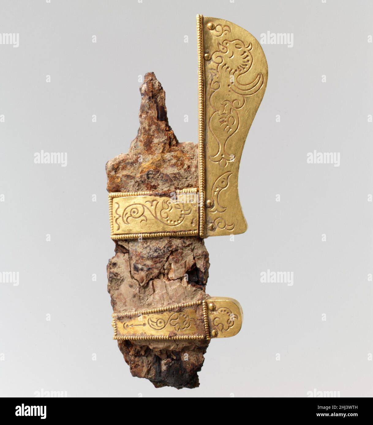 Pezzo da un Dagger di lusso ca. 600 Langobardic questi pezzi - terminale di presa, supporti, nastro di scabbard, tutti in oro - sono tutti che rimangono di un pugnale di lusso. I disegni timbrati di mostri marini e delfini appartengono alla tradizione metallurgica bizantina e appaiono su altri oggetti Langobardici di questo periodo. Questo gruppo di oggetti è stato trovato nella tomba di un orsemano Langobardico, che è stato sepolto nel suo vestito guerriero, con armi, scudo, casco, e gli accessori per il suo cavallo. Ciò che rimane sono i molti pezzi d'oro che avrebbero ornato i suoi vestiti e attrezzature, e attestano la grande ricchezza Foto Stock