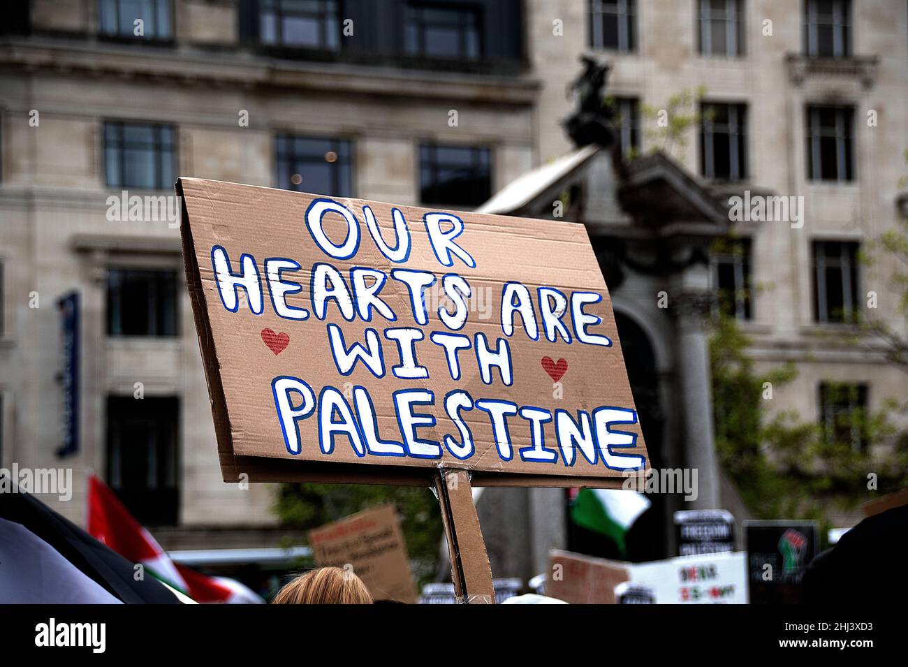 Palastine Placard tenuto a una protesta a Manchester con i nostri cuori sono con la Palestina scritto sul fronte Foto Stock