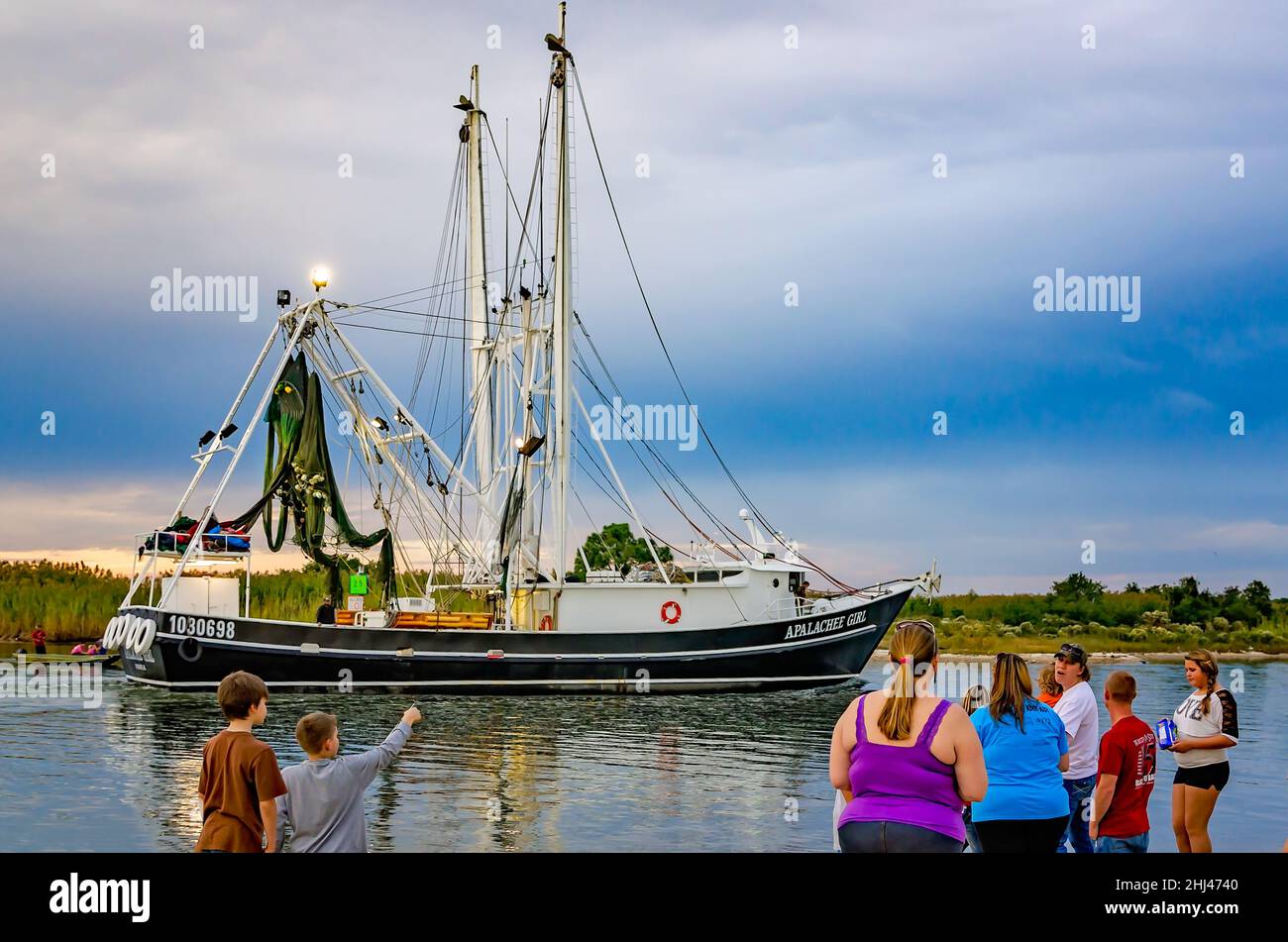 I membri della famiglia guardano come Apalachee Girl, una barca di gamberi, arriva a casa dopo un lungo viaggio di gamberetti, il 27 ottobre 2013, a Bayou la Batre, Alabama. Foto Stock