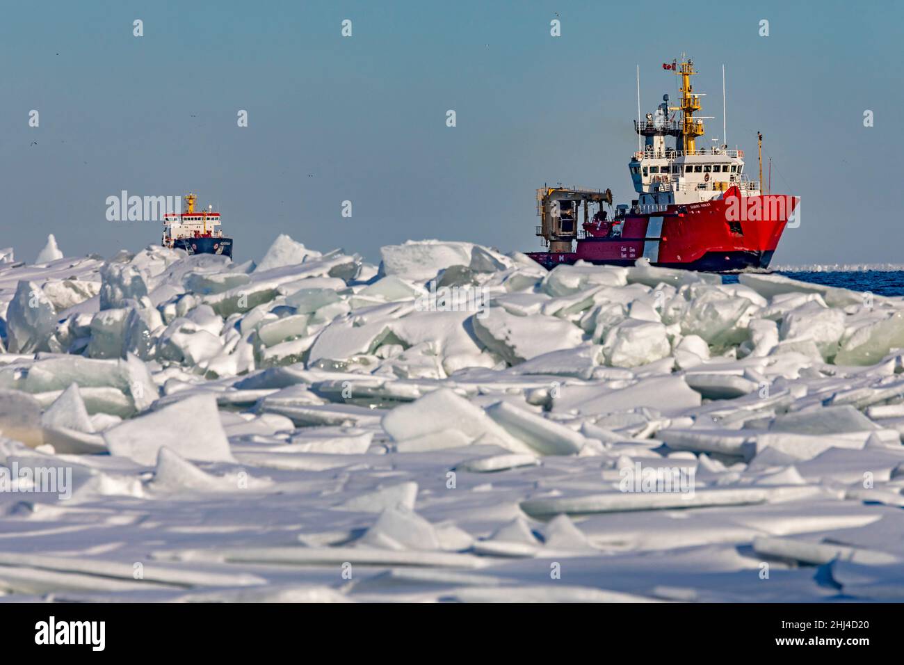 Detroit, Michigan, Stati Uniti. 26th Jan 2022. La nave della Guardia Costiera canadese Samuel Risley conduce l'Algocanada, una petroliera/petroliera chimica, attraverso il ghiaccio sul lago St. Clair mentre entrano nel fiume Detroit. Il clima freddo nella regione ha creato le marmellate di ghiaccio e ha causato problemi di spedizione in alcune località, Credit: Jim West/Alamy Live News Foto Stock