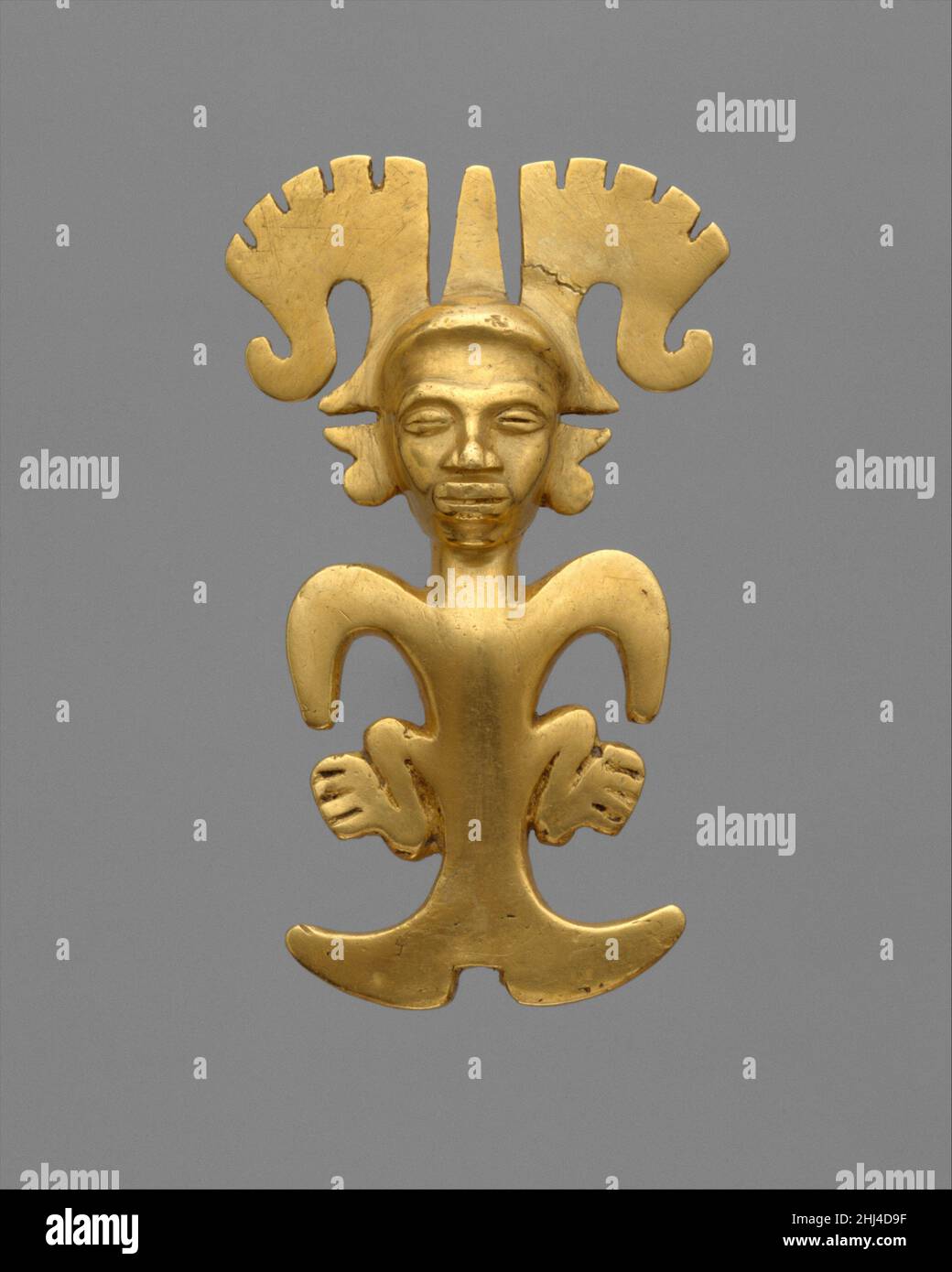 Personaggio stilizzato Ciondolo 5th–7th secolo stile internazionale Cast in oro su un nucleo, questa figura antropomorfa stilizzata integra fluidamente le caratteristiche umane e animali. Un volto umano realistico tappato da un headdress ampio si estende in avanti dal corpo astratto. Le raffigurazioni generalizzate di gambe accovacciate, ali sparse e coda di pesce intagliata possono connotare terra, cielo e mare. Il pendente fa parte di un gruppo di ornamenti di stile e tecnologia uniformi. Sia la combinazione sconcertante di elementi provenienti da creature diverse che le superfici superbamente rifinite fanno si che i pendenti del gruppo si distinguano da ot Foto Stock