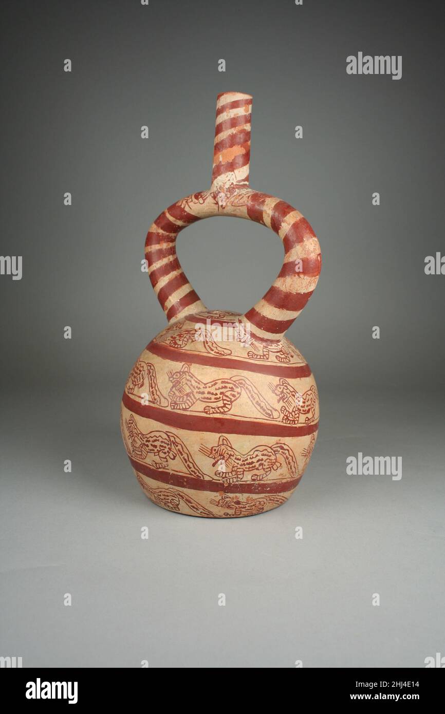 Stirrup Spout bottle with felines 4th–7th Century Moche questa bottle Stirrup-but, realizzata da ceramisti della cultura moche del Perù tra il 5th e il 8th secolo d.C., raffigura una serie di felini che procedono su una rampa a spirale. Il disegno a spirale viene ripetuto sul beccuccio insieme a due teste a profilo felino all'intersezione dei tre elementi del beccuccio. Gli artisti Moche hanno raffigurato gli animali con cura e precisione, consentendo così di identificare queste creature come gatti di pampas, piccoli felini selvatici nativi del Sud America, in base alle strisce sulle gambe, alle marcature del corpo e alle loro code folli Foto Stock