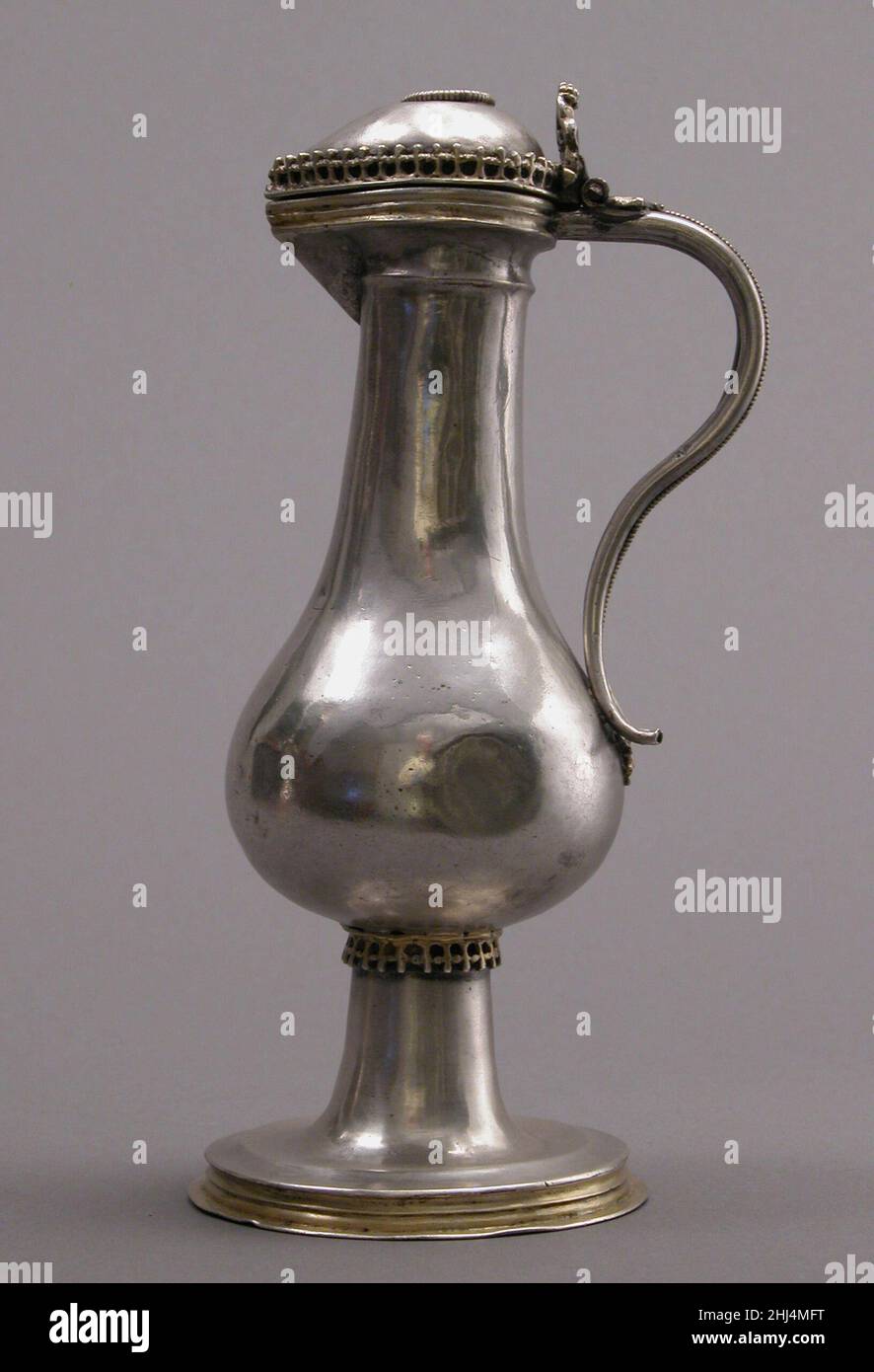 Cruet 1518 German questo paio di vasi d'argento assomiglia molto ai flagoni d'argento maneggiati appesi sul ripiano nell'angolo superiore destro del dipinto vicino. Tali oggetti sono stati creati per l'uso sulla tavola, dove riflettono lo stato elevato dei loro proprietari. Questa coppia è stata utilizzata nei servizi della chiesa. La loro scala di riduzione riflette la piccola quantità di vino utilizzata nella Messa prima della riforma. Per la liturgia, tali oggetti sono sempre stati fatti a coppie (per il vino e l'acqua). Poiché questi due liquidi erano combinati nel calice, i cruetti erano spesso distinti dalle lettere V (vinum) e A. Foto Stock