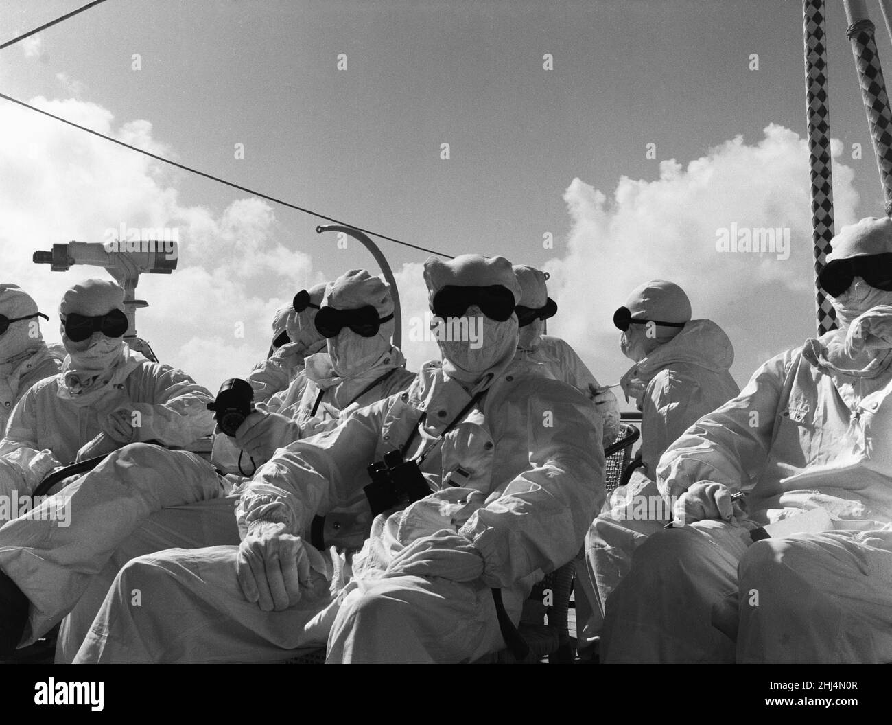 I membri della stampa e le valutazioni navali a bordo di HMS Alert 35 miglia al largo di Malden Island, Kiribati. Visto qui vestito con abiti protettivi noti come abiti di Goon. L'equipaggio e i passeggeri delle navi dove si trovano per assistere alla seconda prova della bomba a idrogeno della Gran Bretagna. 31st maggio 1957 Foto Stock
