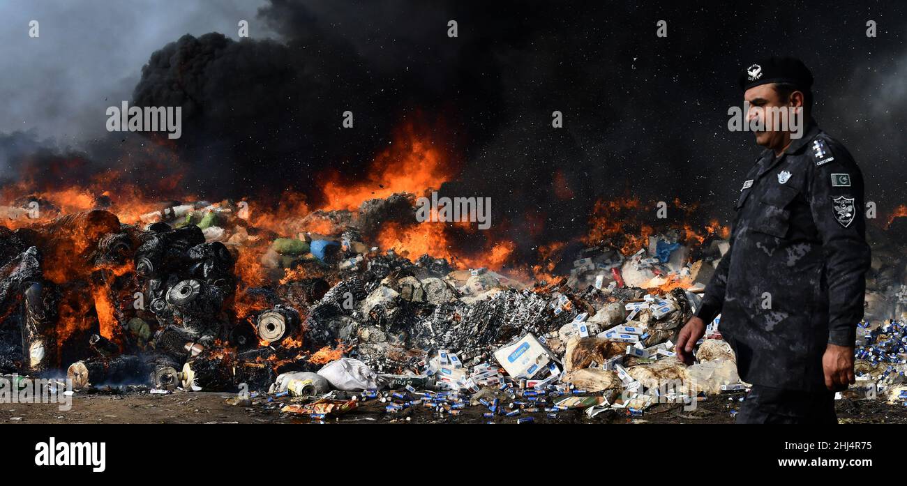 Lahore, Punjab, Pakistan. 26th Jan 2022. I funzionari doganali pakistani bruciano per distruggere le merci contrabbandiate (sigarette, tabacco da masticare, noci di Betel, fuochi d'artificio e altre cose vicino al confine di Wagha alla vigilia della giornata doganale mondiale a Lahore. Un mattone di droga confiscata, sigarette e altri beni che sono stati sequestrati da diverse aree, durante la cerimonia di lancio di campagne di sensibilizzazione in tutta la provincia, organizzato dalla dogana pakistana tenutasi al confine di Wagha a Lahore (Credit Image: © Rana Sajid Hussain/Pacific Press via ZUMA Press Wire) Foto Stock