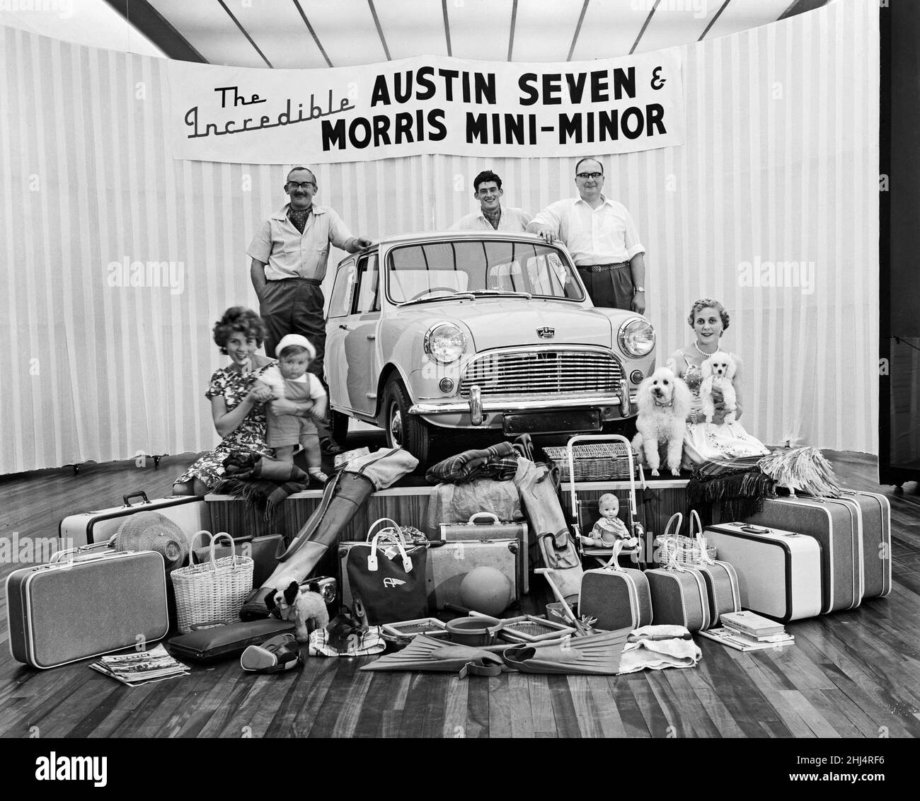 Una visione che dimostra la capacità di stoccaggio della nuova Austin Seven (in seguito ribattezzata come la Mini) in mostra ad un Motor show a Birmingham. Così come il montaggio di cinque adulti, un bambino e due cani da compagnia nell'auto, c'era anche abbastanza spazio per il bagaglio in mostra. 24th agosto 1959. Foto Stock