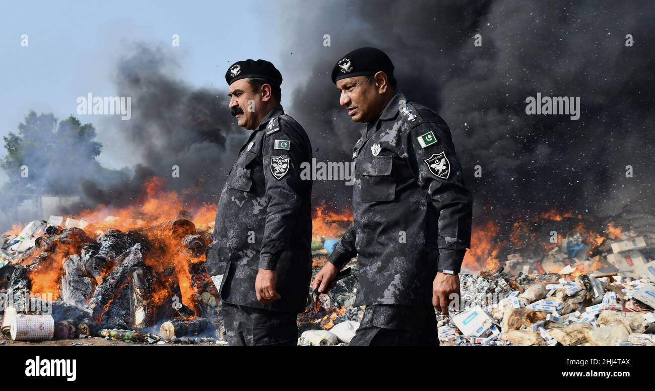 Lahore, Punjab, Pakistan. 26th Jan 2022. I funzionari doganali pakistani bruciano per distruggere le merci contrabbandiate (sigarette, tabacco da masticare, noci di Betel, fuochi d'artificio e altre cose vicino al confine di Wagha alla vigilia della giornata doganale mondiale a Lahore. Un mattone di droga confiscata, sigarette e altri beni che sono stati sequestrati da diverse aree, durante la cerimonia di lancio di campagne di sensibilizzazione in tutta la provincia, organizzato dalla dogana pakistana tenutasi al confine di Wagha a Lahore (Credit Image: © Rana Sajid Hussain/Pacific Press via ZUMA Press Wire) Foto Stock