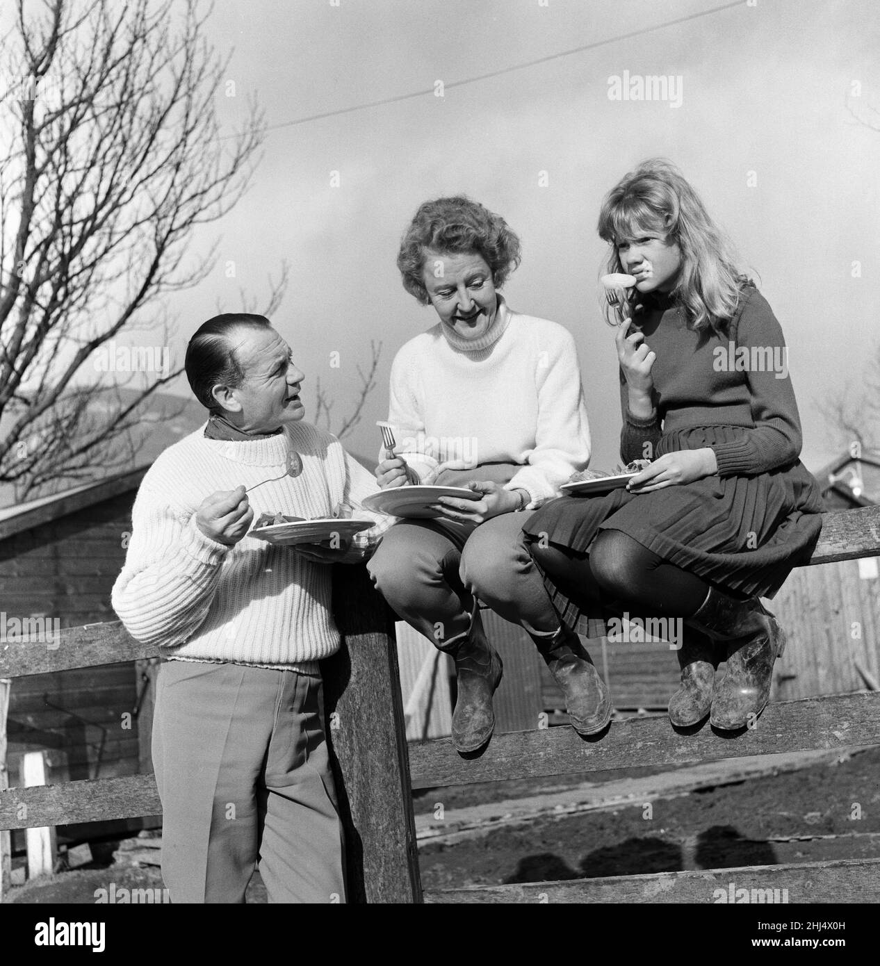 L'attore John Mills, la moglie Mary Hayley Bell e la loro figlia Hayley Mills hanno illustrato al sole a Downham, Lancashire, studiando la sceneggiatura del film 'Whistle Down the Wind'. Il film è stato girato in una fattoria lì e Hayley è in esso. Il copione è stato adattato da un romanzo scritto da Mary Hayley Bell. 21st febbraio 1961. Foto Stock