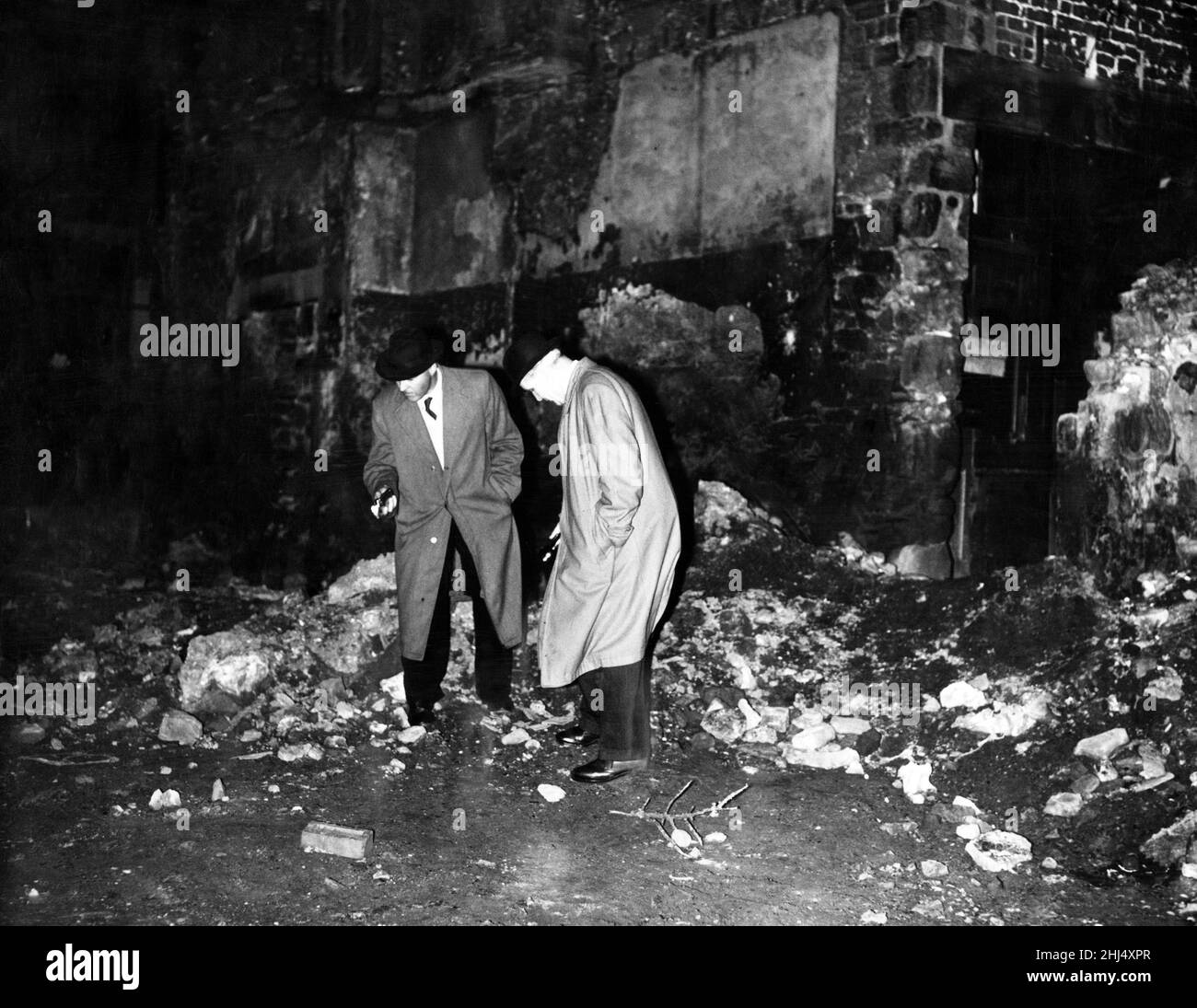 La notte del 26th febbraio 1959, 71 anni di negoziante, la signora Amy Browell fu assassinata, i suoi locali furono anche saccheggiate e la cassa si svuotò. Nella foto, la polizia cerca l'arma dell'omicidio tra detriti e macerie in Churchill Street, vicino al negozio di Mrs Browell. 26th febbraio 1959. Foto Stock