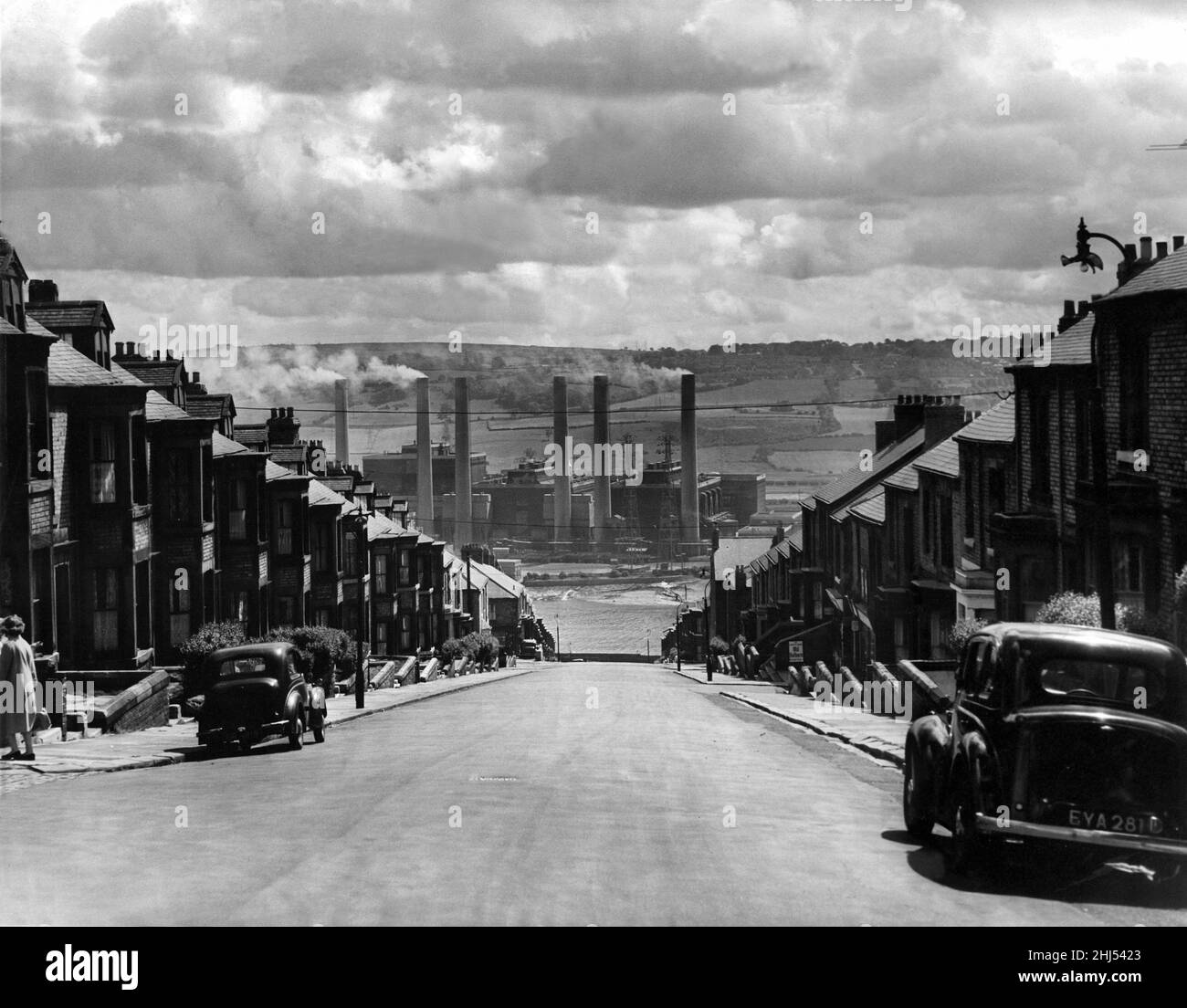 Questa foto scattata nel 1960 mostra una visione immortalata 10 anni dopo nel famoso film di Michael Caine Get carter.i sei camini della centrale elettrica di Dunston salgono in aria con campi ondulati dietro di loro – nel punto in cui il MetroCenter si trova ora a Gateshead. L'elettricità proveniente dalla stazione forniva Northumberland, County Durham, Cumberland, Yorkshire e fino a nord di Galashiels in Scozia, così come Tyneside. Divenne obsoleta e chiusa nel 1981, essendo demolita cinque anni dopo, all'inizio dei lavori sul MetroCenter. La foto è stata scattata in mezzo alle spettacolari terrazze di Clara Street a Newcastle Foto Stock