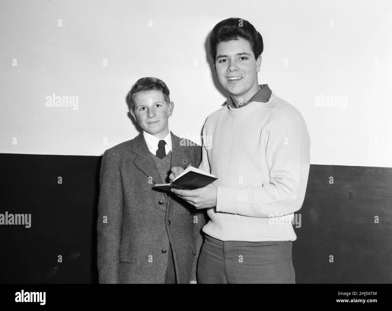 Cliff Richard e The Shadows backstage al Regal, Cambridge, 10th novembre 1959. Cliff firma un libro di giovani cacciatori autografi Foto Stock