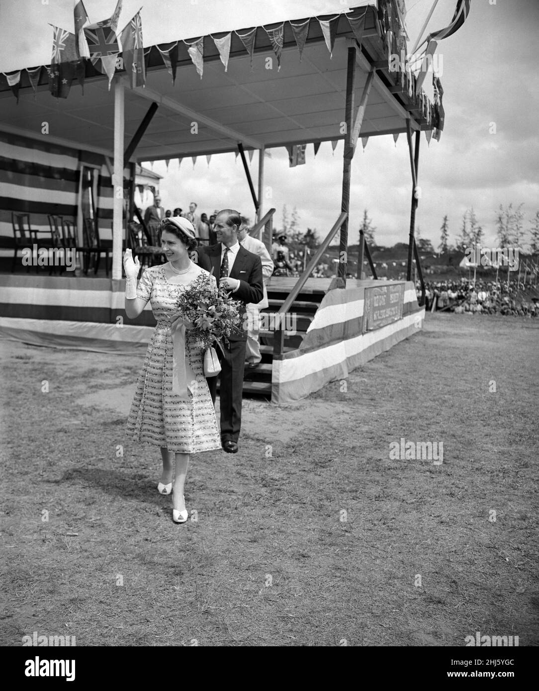 La regina Elisabetta II e il duca di Edimburgo si sono mossi dalla folla mentre lasciano lo stadio a Calabar, Nigeria. 8th febbraio 1956. Foto Stock