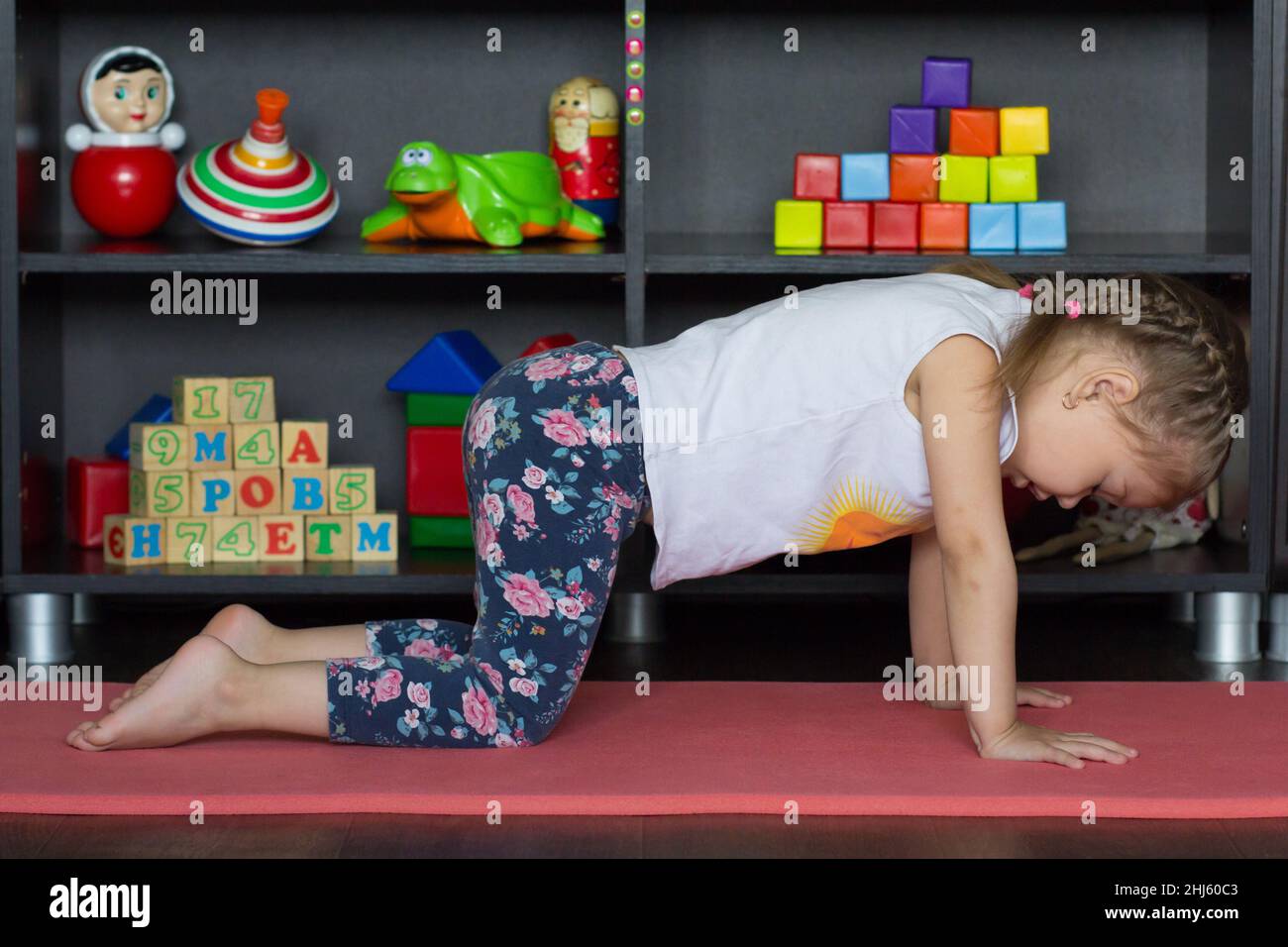 Bambina che fa yoga gatto o mucca posa essere in posizione neutrale  piatto-indietro Foto stock - Alamy