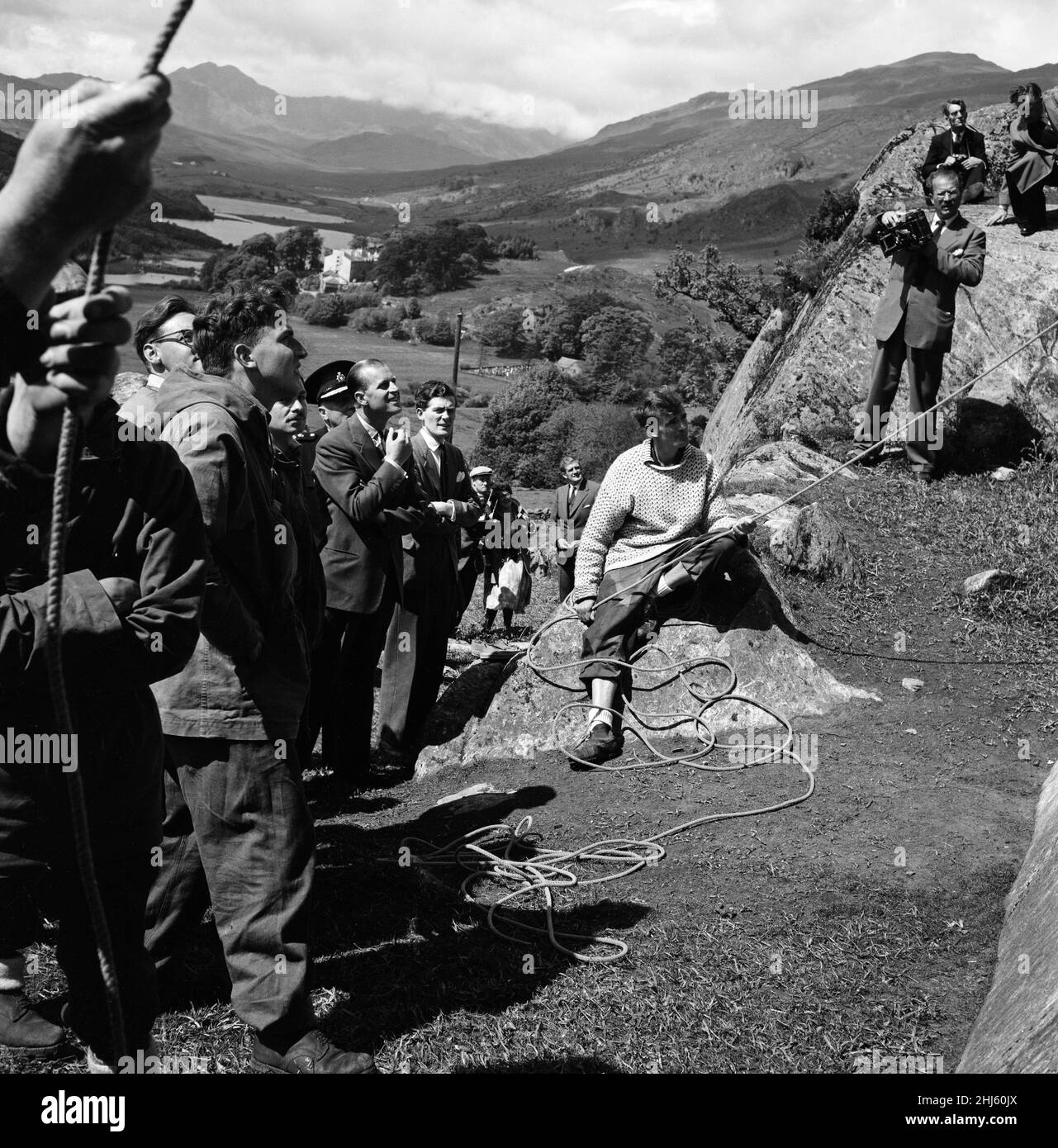 Principe Filippo, Duca di Edimburgo, nel Galles del Nord. Il Duca osserva con interesse gli sforzi dei membri del centro ricreativo nazionale Snowdonia a Capel Curig, scalando le pareti della scogliera durante la sua visita. 1st giugno 1956. Foto Stock