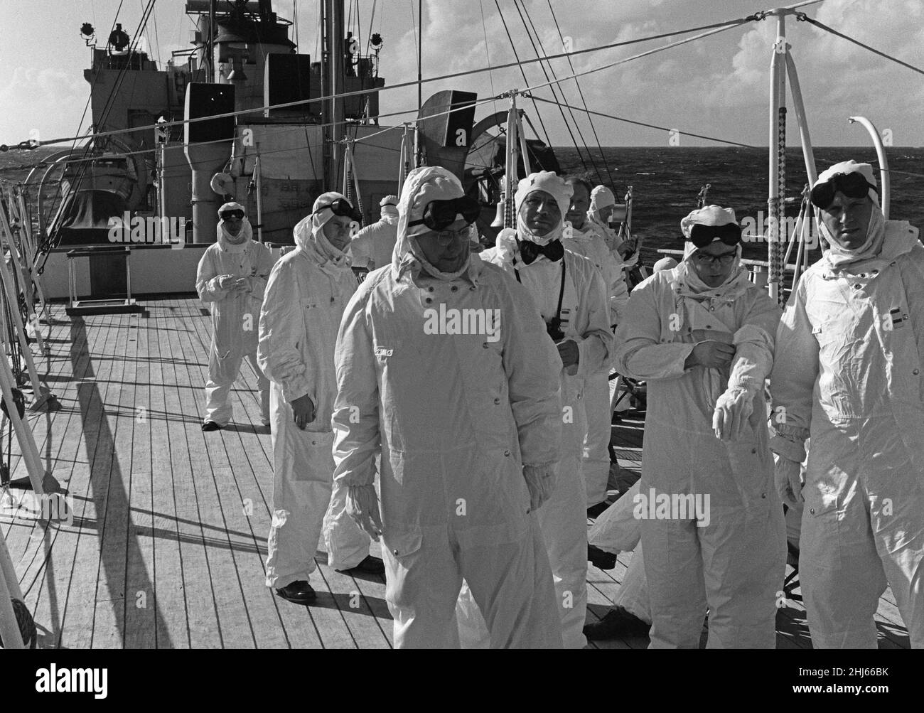 I membri della stampa e le valutazioni navali a bordo di HMS Alert 35 miglia al largo di Malden Island, Kiribati. Visto qui vestito con abiti protettivi noti come abiti di Goon. L'equipaggio e i passeggeri delle navi dove si trovano per assistere alla seconda prova della bomba a idrogeno della Gran Bretagna. 31st maggio 1957 Foto Stock