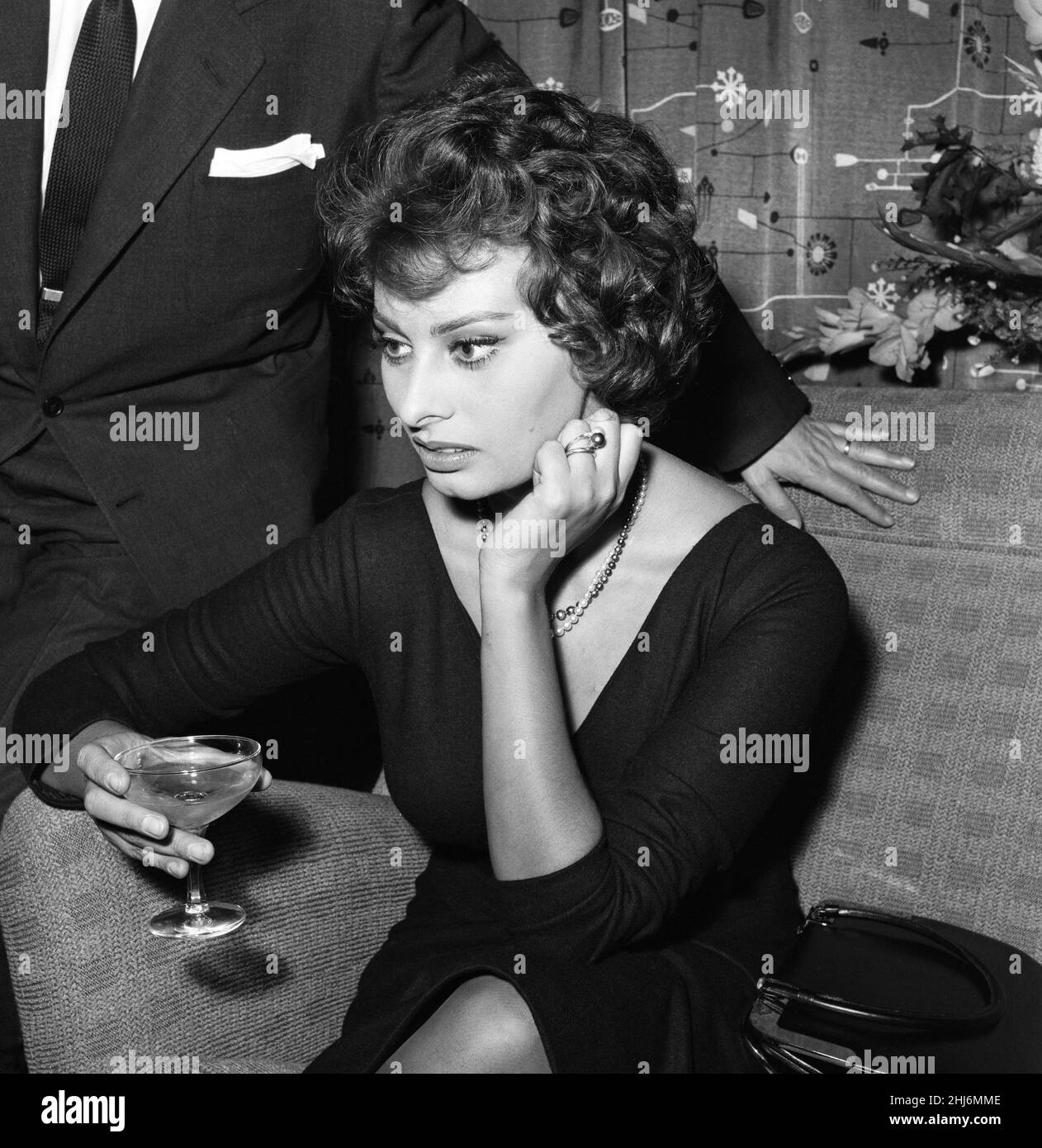 Sophia Loren raffigurato seduto su una sedia all'aeroporto di Londra. È a Londra per fare un film di guerra. Il suo matrimonio per procura con un uomo divorziato, il produttore cinematografico italiano Carlo ponti, è stato condannato dal vaticano. Le è stato detto che alcune persone sono state stupiti, in risposta a questo si è appoggiata in avanti, i suoi occhi lampeggiante, 'sono?' Ha detto, 'bene - lasci che parlino'.18th ottobre 1957. Foto Stock