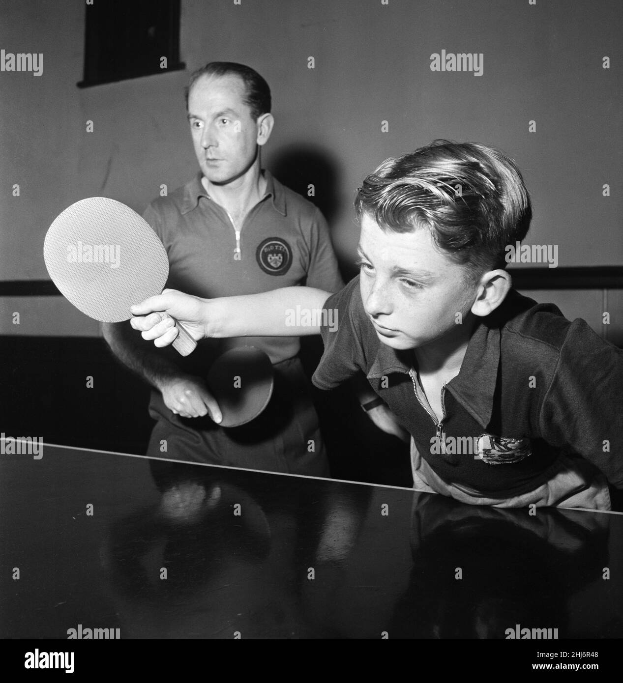 Ken Stanley, ex ping-pong internazionale inglese, sarà partner da David Stanley (12) suo figlio, nel doppio maschile ai campionati di tennis da tavolo del Nord d'Inghilterra a Manchester il mese prossimo. Sono raffigurati in formazione per le doppie, Ken gestisce una scuola di ping-pong a Burnley. 1st settembre 1957. Foto Stock