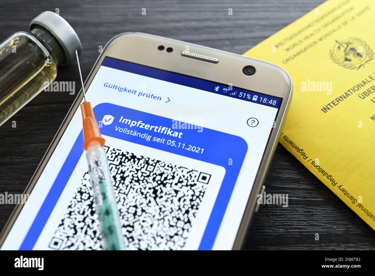 Impfzertifikat auf smartphone, Impfausweis und Impfspritze, Symbolfoto digitaler Impfnachweis Foto Stock