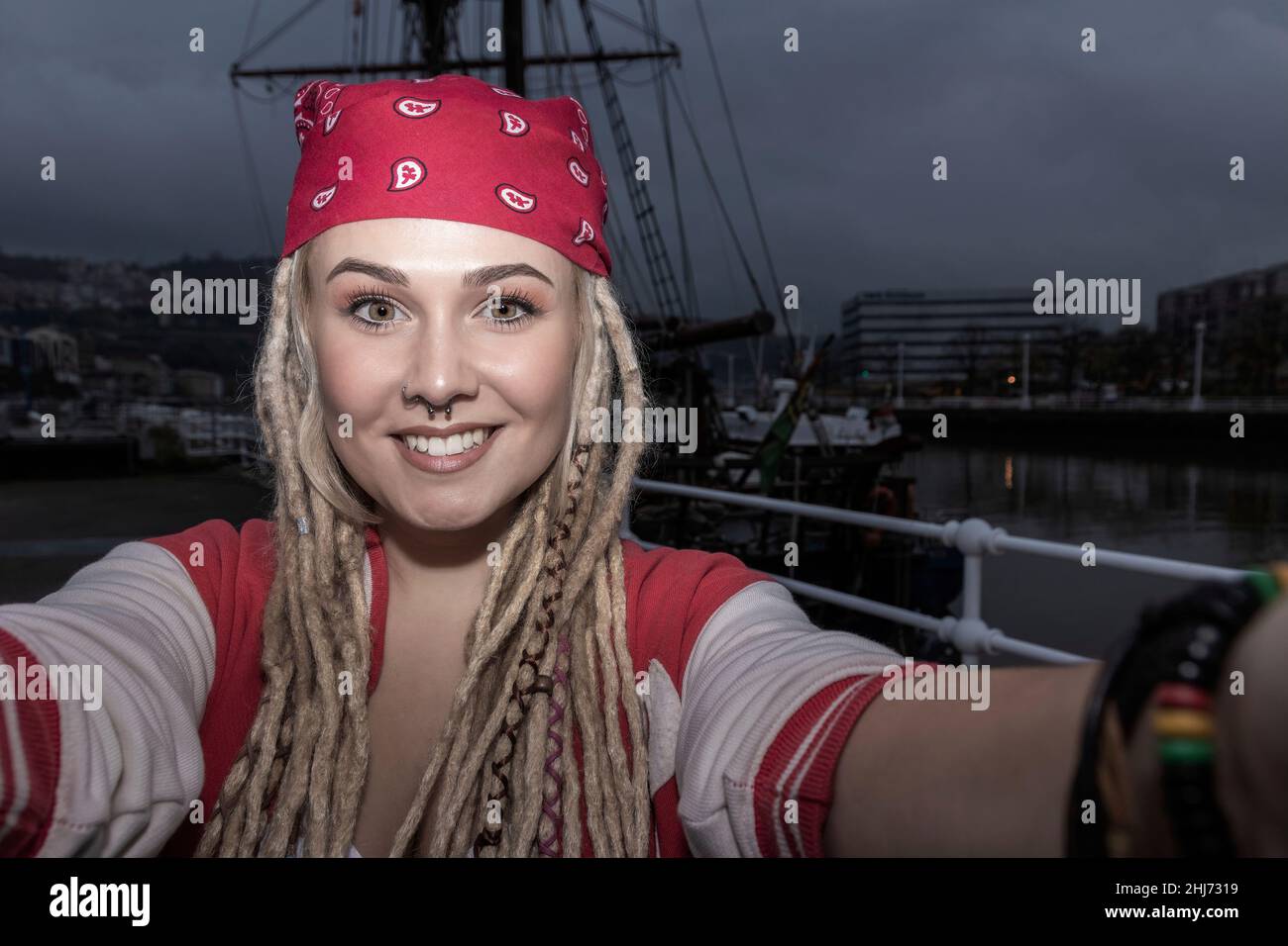 donna bionda graziosa con i dreadlocks che sorridono mentre prendono un selfie Foto Stock