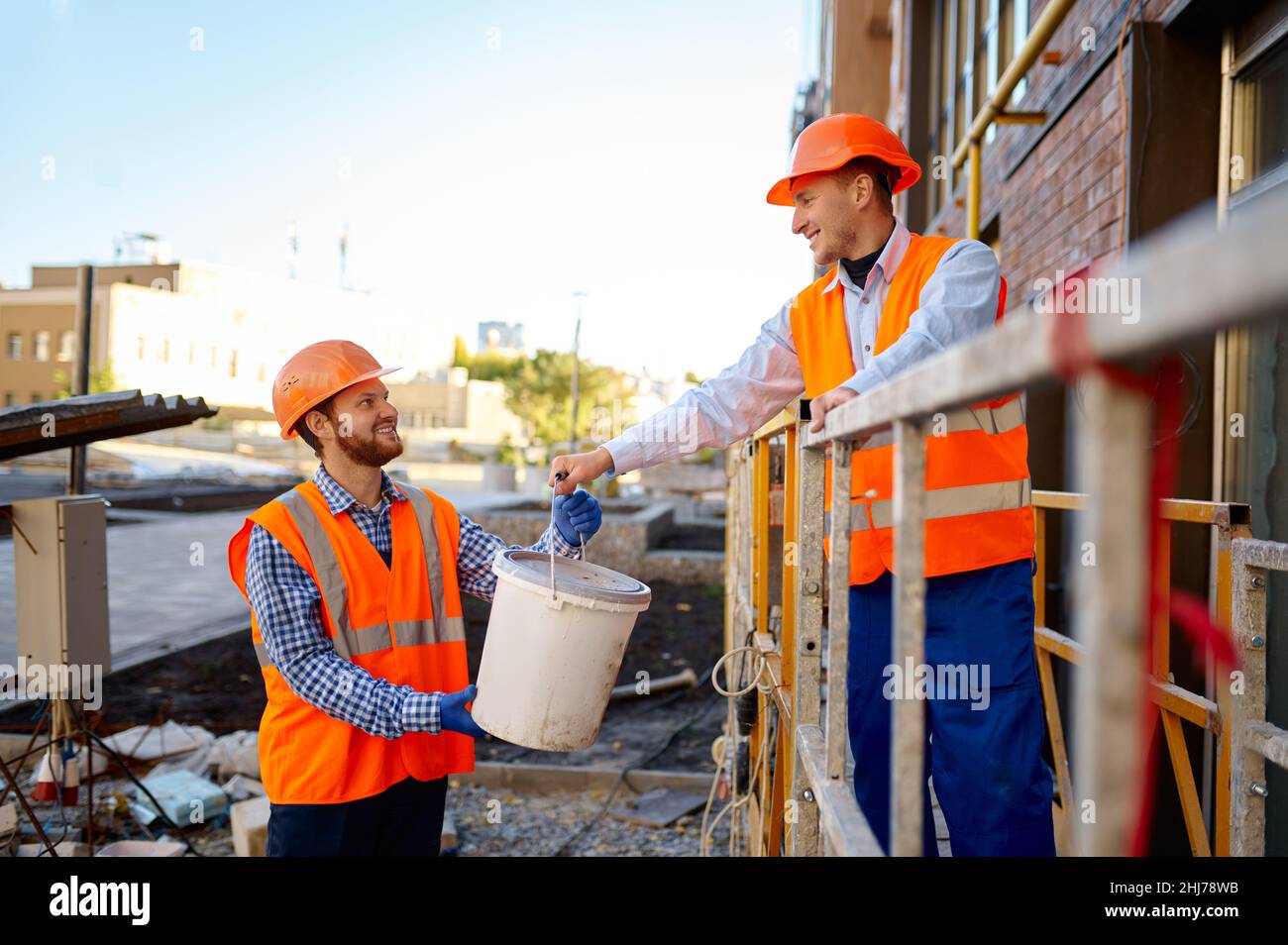 I costruttori si aiutano a vicenda in cantiere Foto Stock